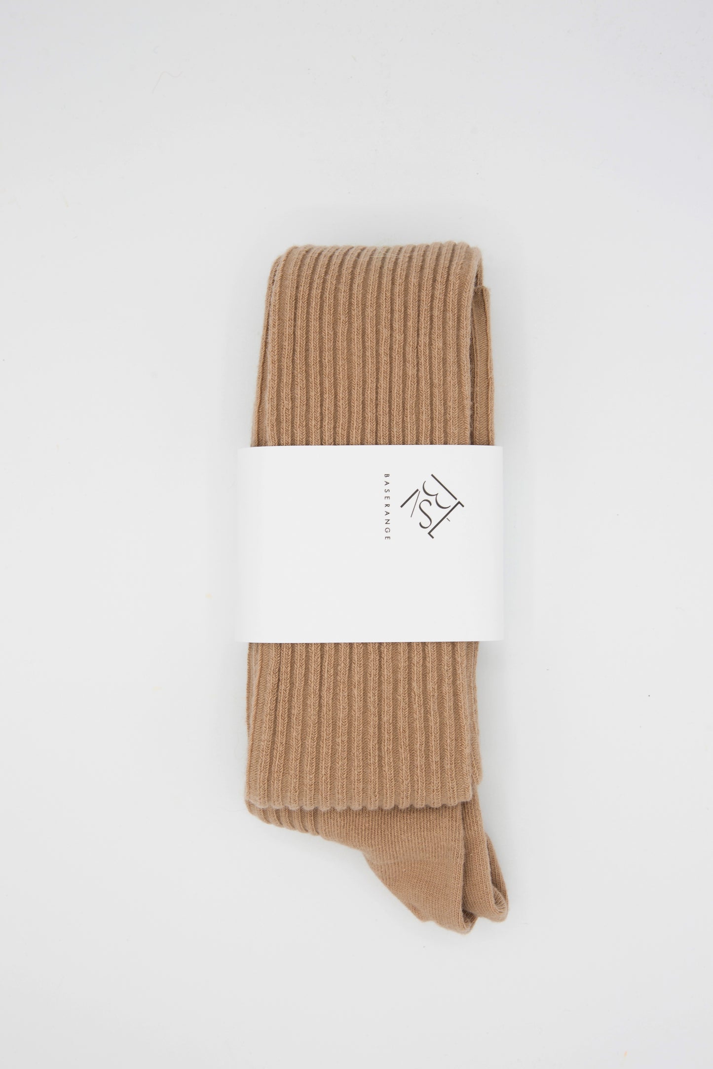 A sustainably produced pair of ribbed over-knee socks in camel, made from an organic cotton blend by Baserange.