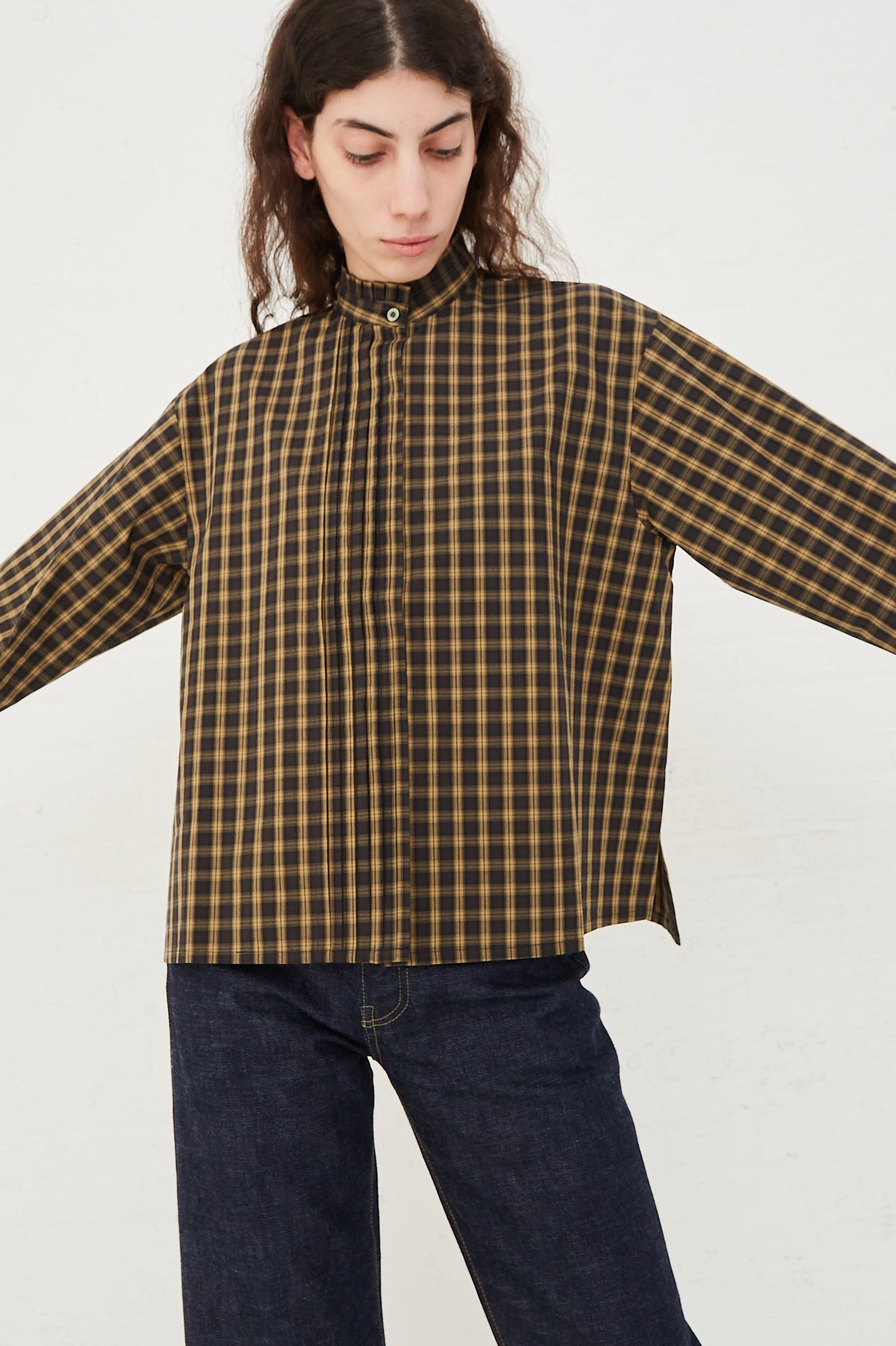 CHIMALA Pleated Stand Collar Shirt in Yellow Check - Oroboro Store | Front view and up close. Model's arms raised to the side.