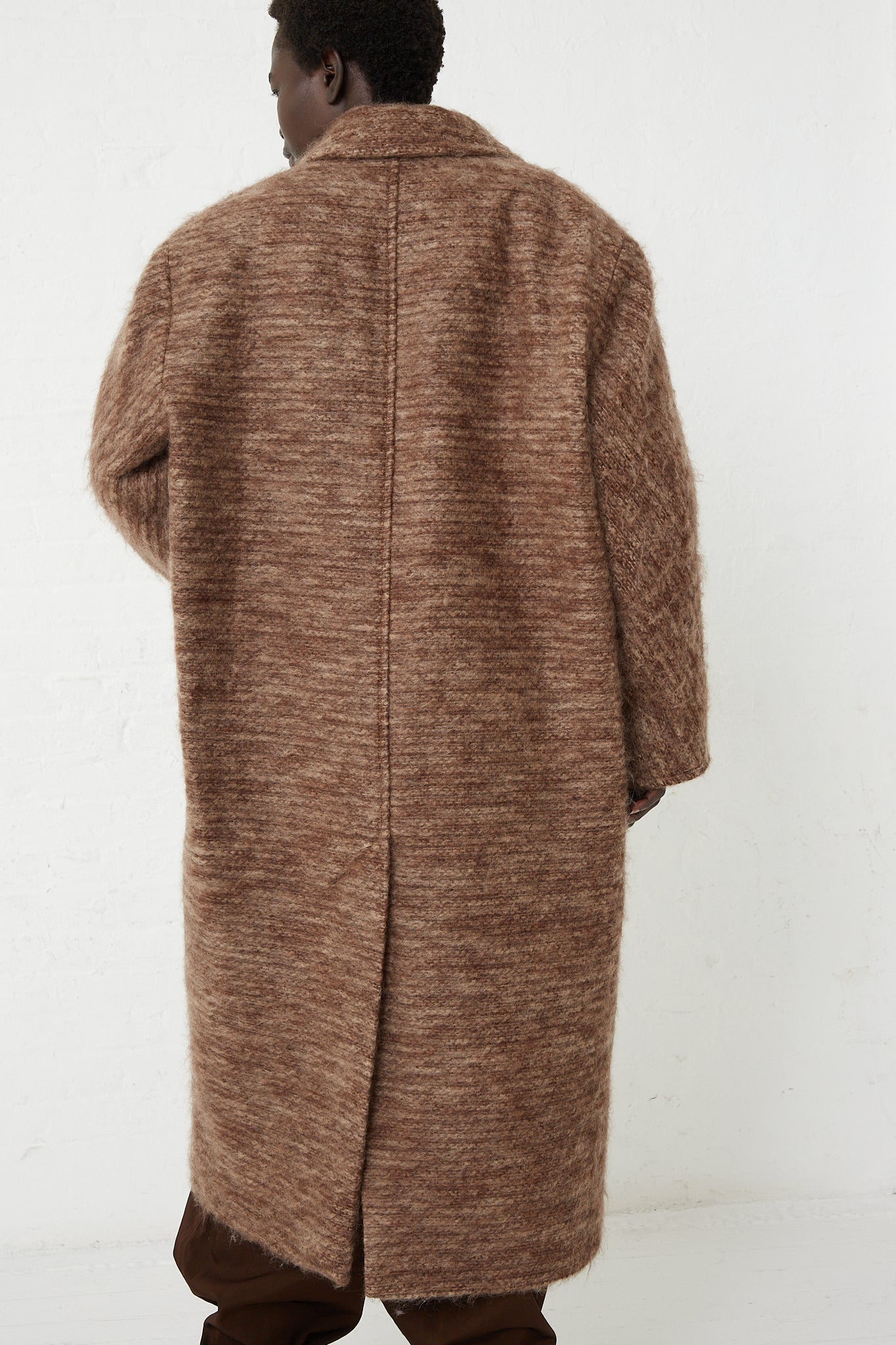 The back of a woman wearing an exclusive Veronique Leroy Wide Shoulder Tailor Coat in Oak made with fine mohair fabric.
