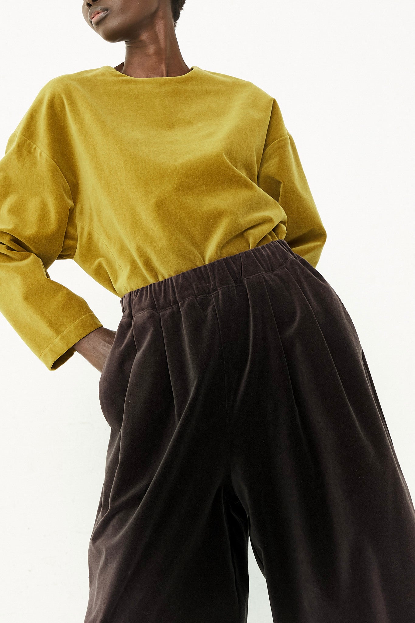 A woman in a yellow top and black wide leg pants, wearing a Cotton Velveteen Wide Pants by Black Crane.