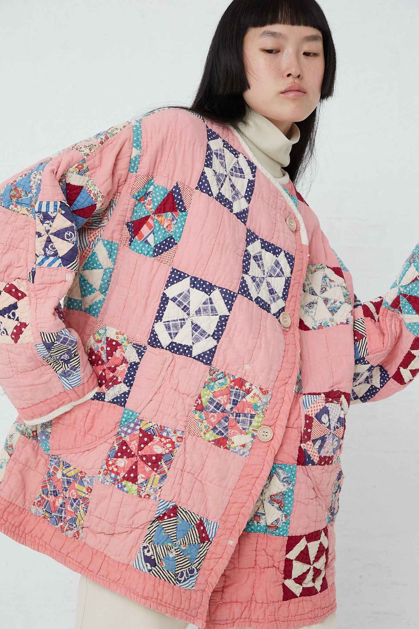 A woman wearing an As Ever Quilt Jacket in Pink. Jacket closed.