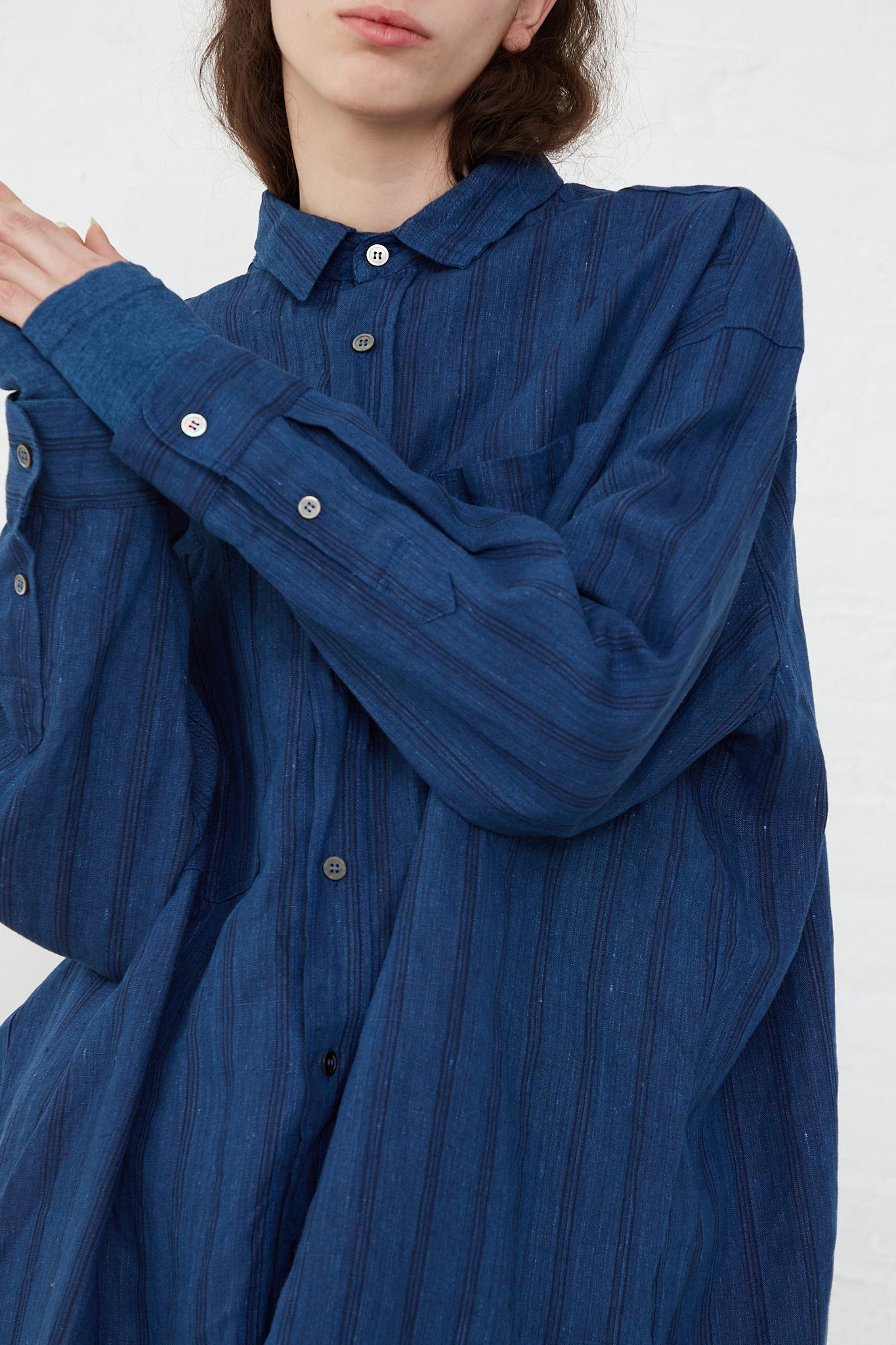 A model wearing a relaxed fit Ichi Antiquités Woven Linen Shirt in Indigo Stripes.