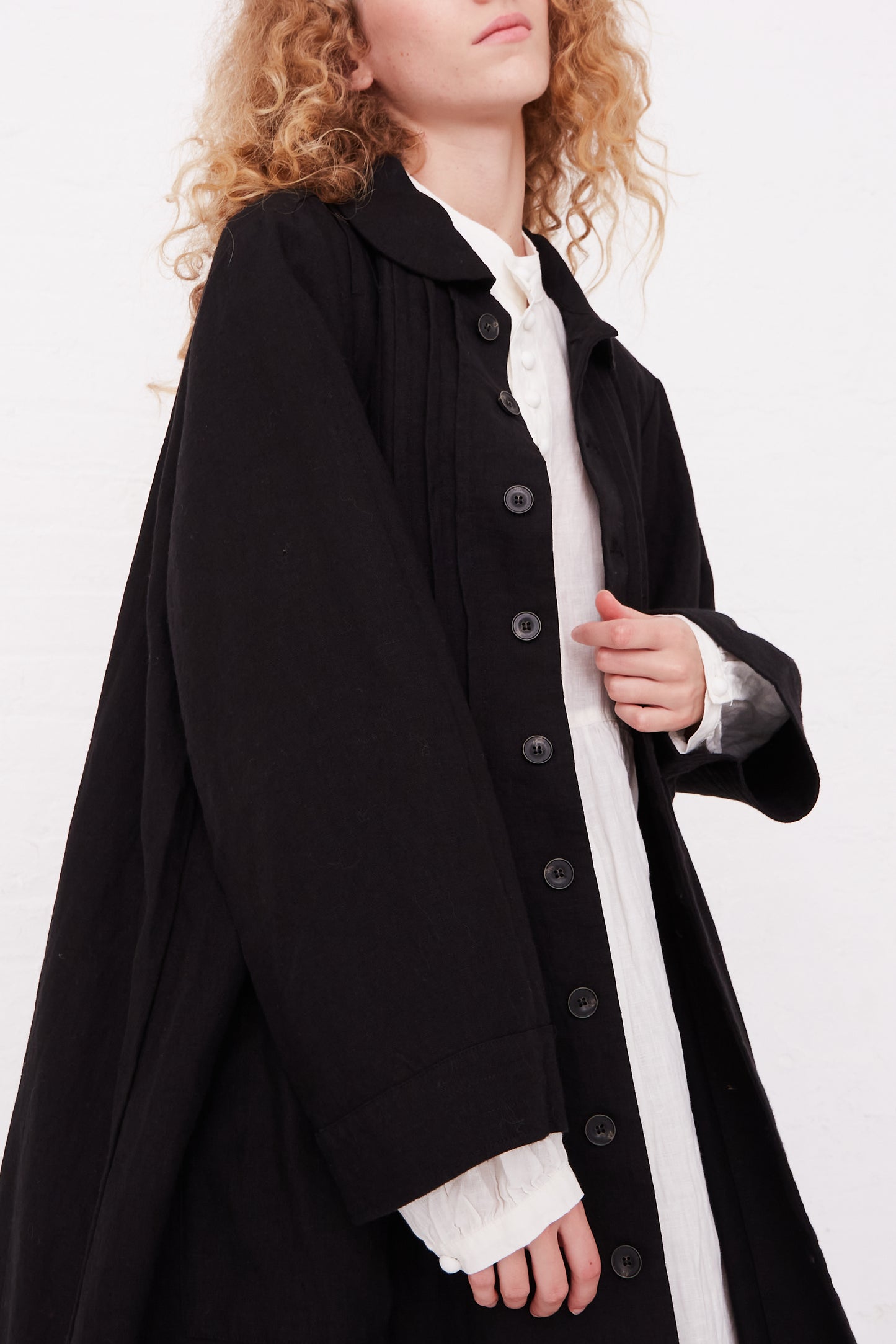 A woman wearing a Kortrijk Linen Jacket in Black by Ichi Antiquités with oversized patch pockets.