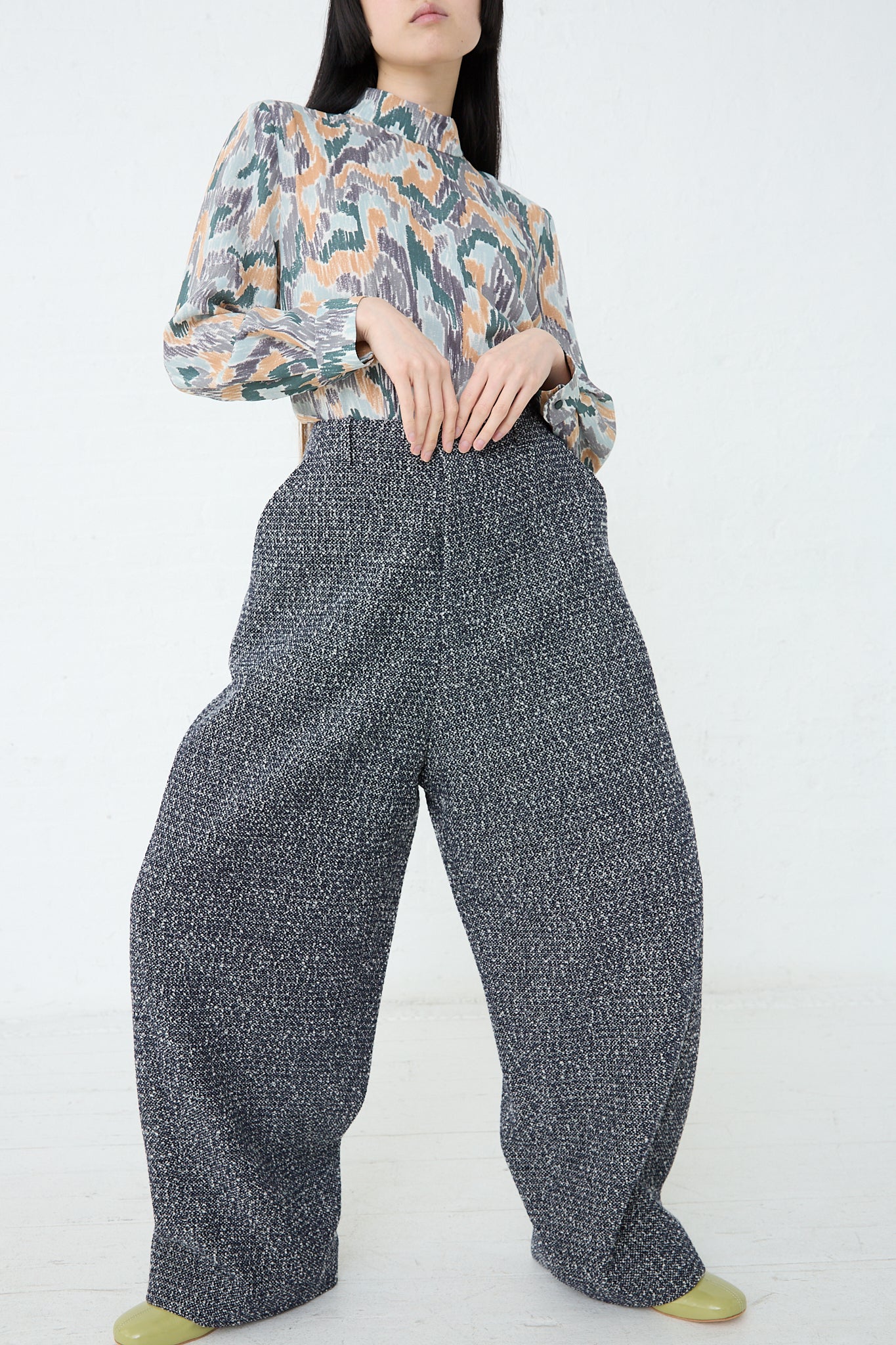 A woman wearing Mina Perhonen's Predawn Trouser in Navy Mix made in Japan and a floral blouse with a relaxed fit.