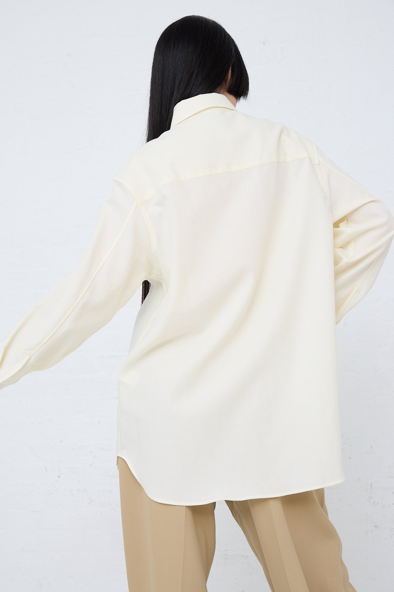 The back of a woman wearing a long sleeve Santos Overshirt in Parchment by Studio Nicholson.