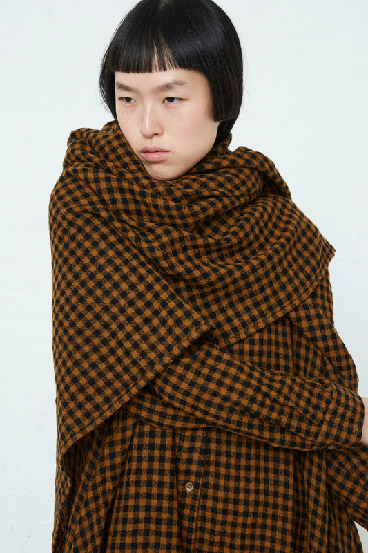 A woman wearing an Ichi Wool Check Scarf in Mustard and Black and checkered dress.