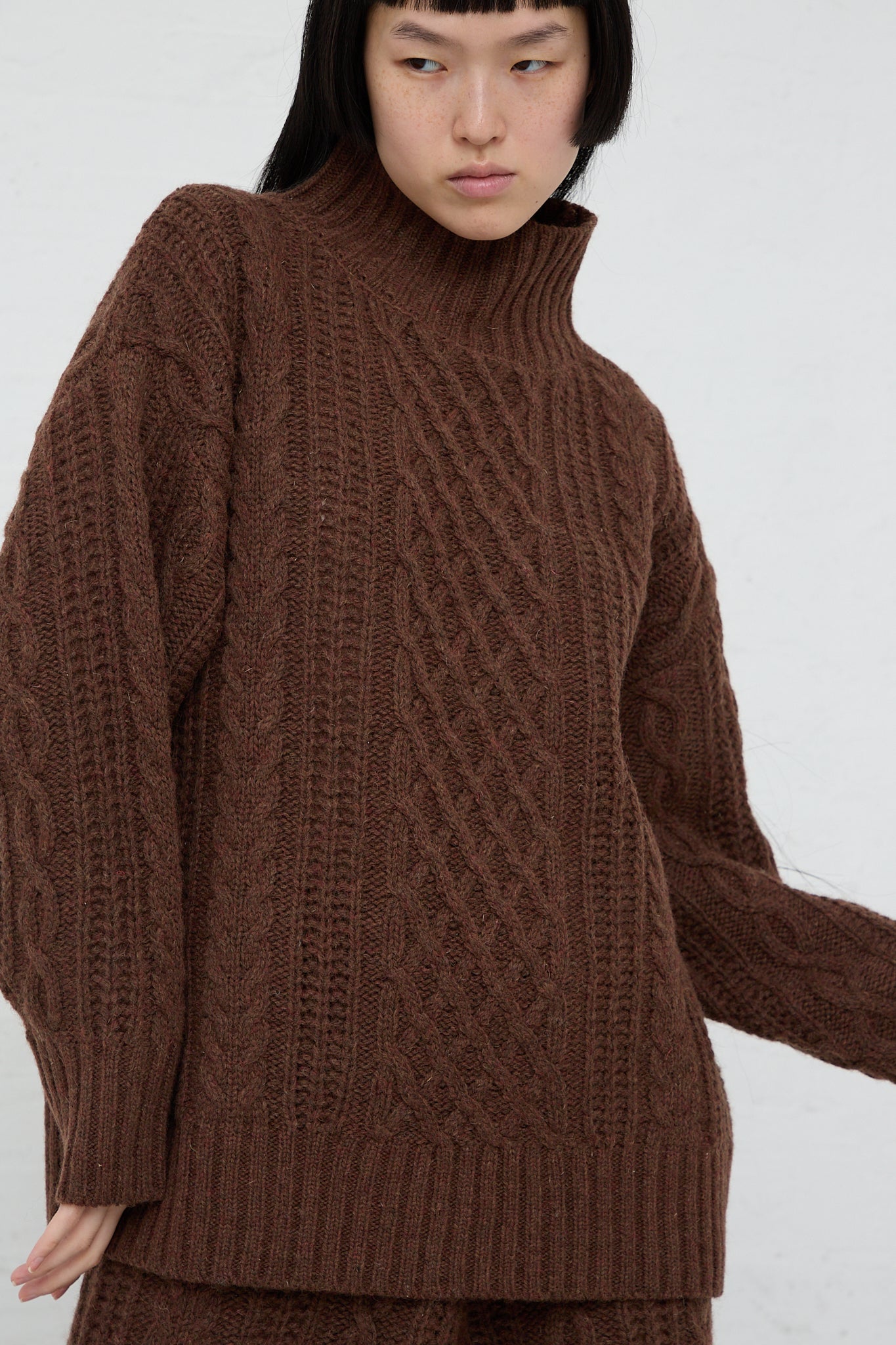 The model is wearing an Ichi Knit Turtleneck Pullover in Brown.