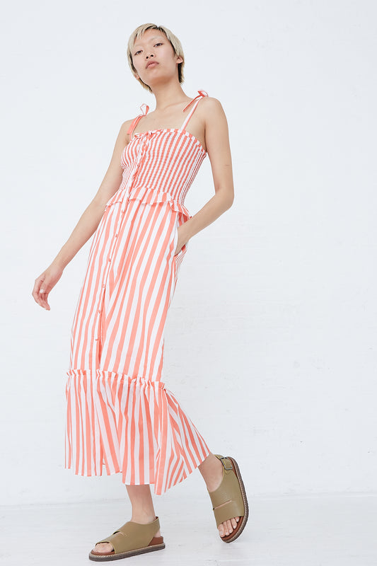 The model is wearing an Alberica Dress in Coral Stripe by Loretta Caponi.