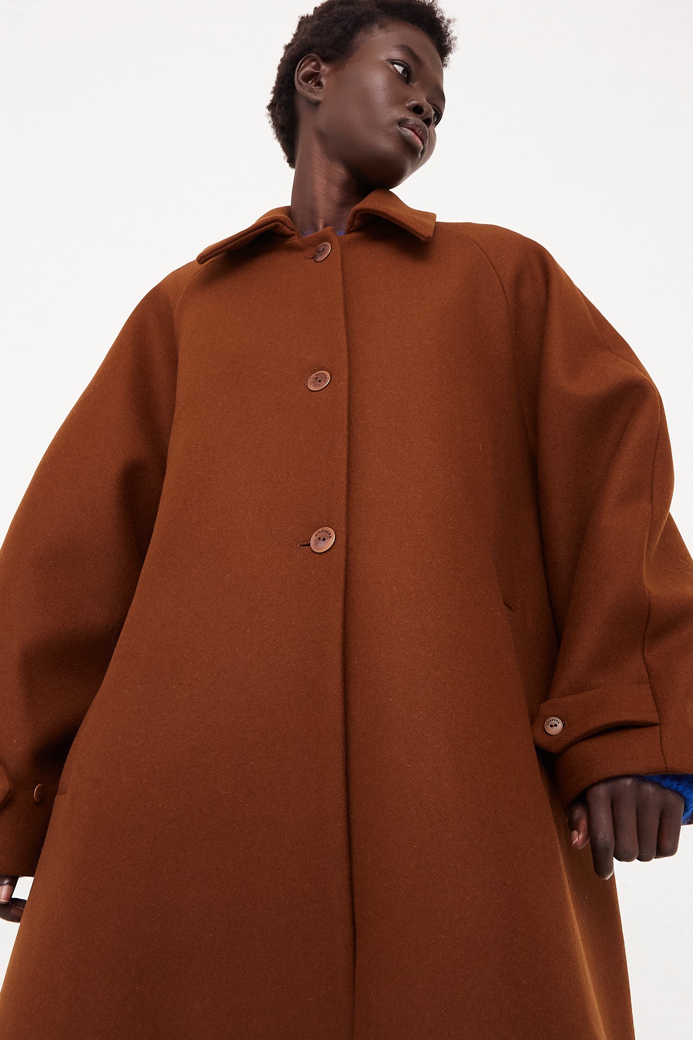 CORDERA Wool Coat Camel | Oroboro Store | Front image of coat upclose buttoned up on model hands out of pocket