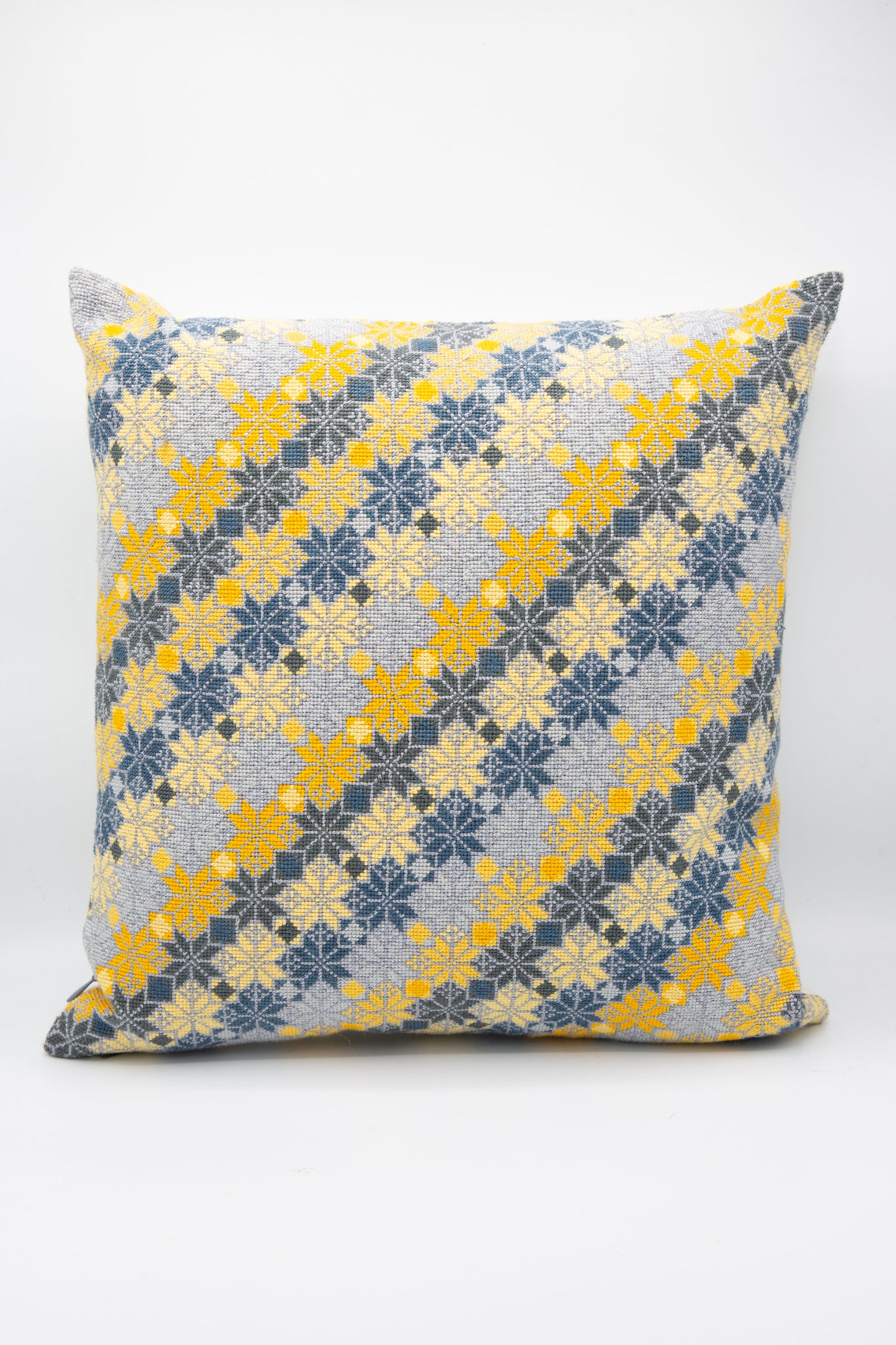 A Moon of Bethlehem Hand Embroidered Pillow in Slate and Lemon by Kissweh with a floral pattern.