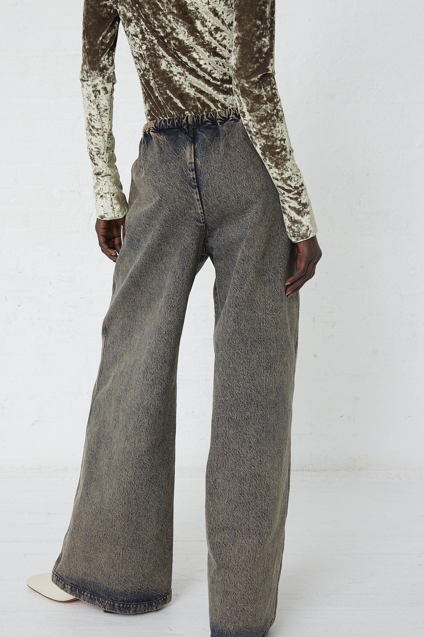 The back view of a woman rocking her Denim Belted Trousers in Acid Wash Denim by Veronique Leroy.