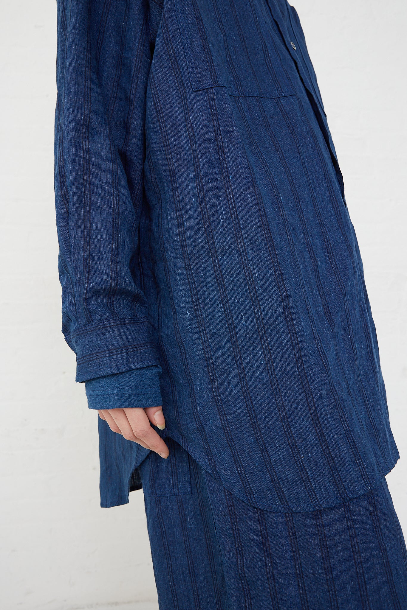 A woman wearing a relaxed fit blue striped Ichi Antiquités woven linen shirt.