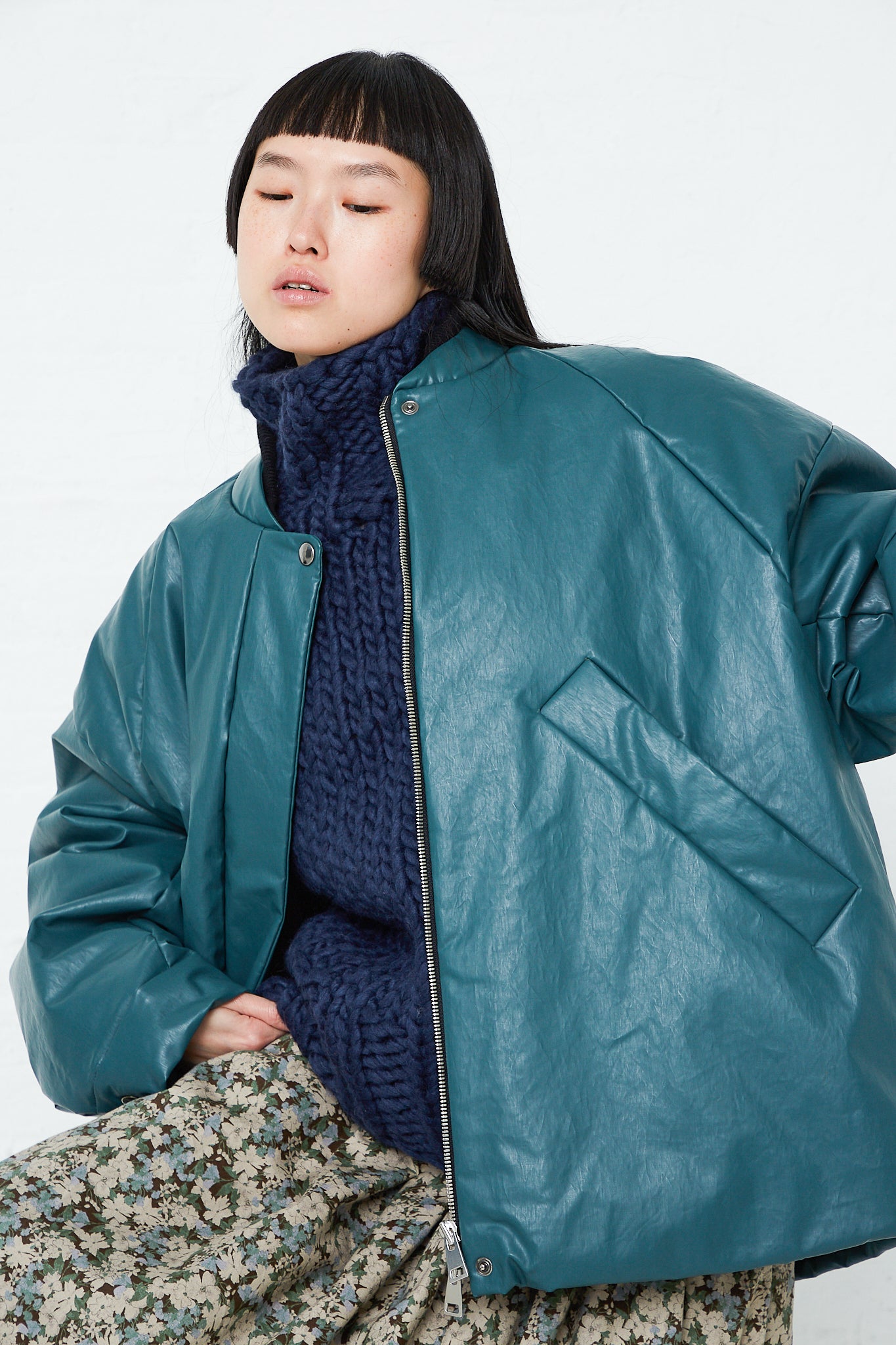 A woman wearing an oversized Padded Bomber Oil jacket in Forest by Kassl.