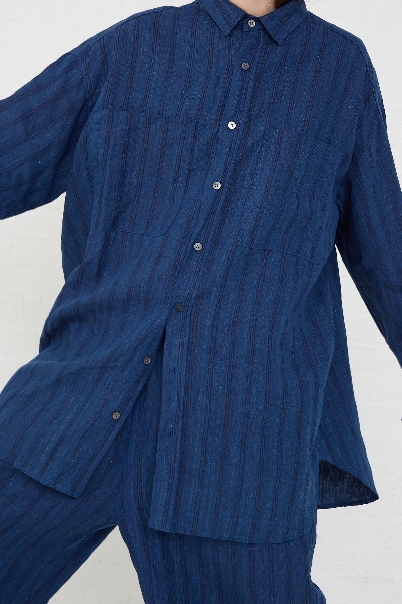 A model wearing a relaxed fit Ichi Antiquités Woven Linen Shirt in Indigo Stripes and pants.