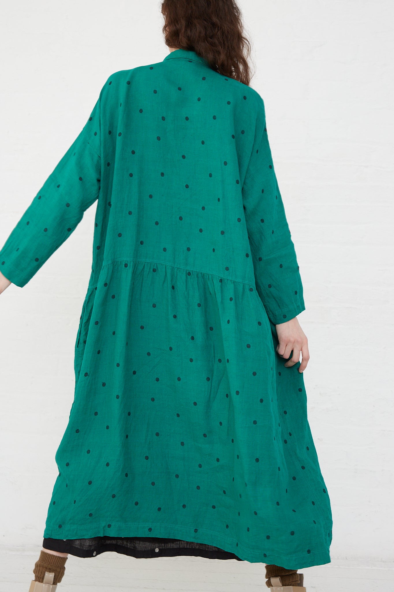 The back of a woman wearing an Ichi Antiquités Linen Dot Dress in Green and Black, gathering at the waist.