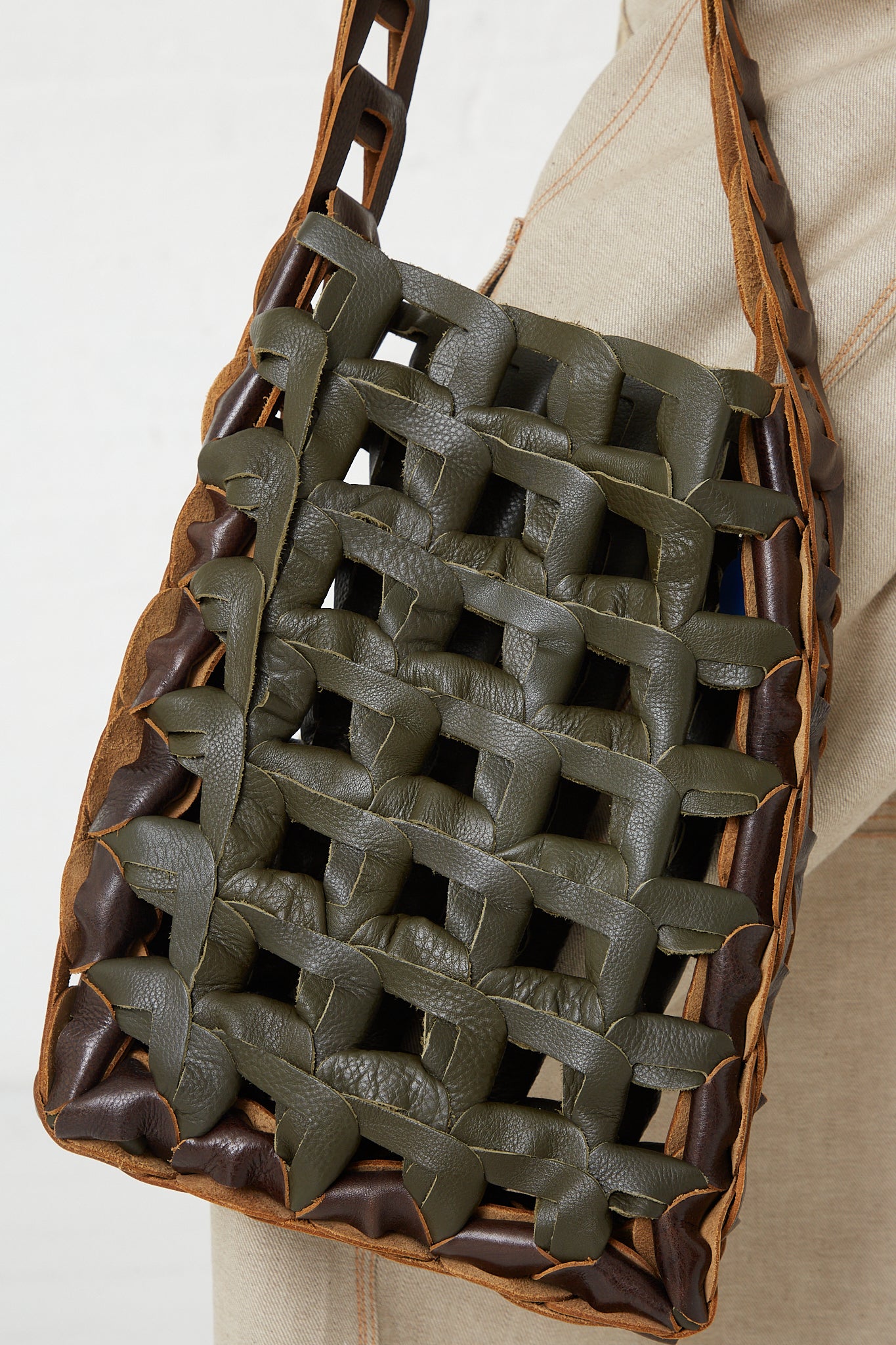 A woman is holding a SC103 Leather Medium Links Tote in Herb. Up close view. 