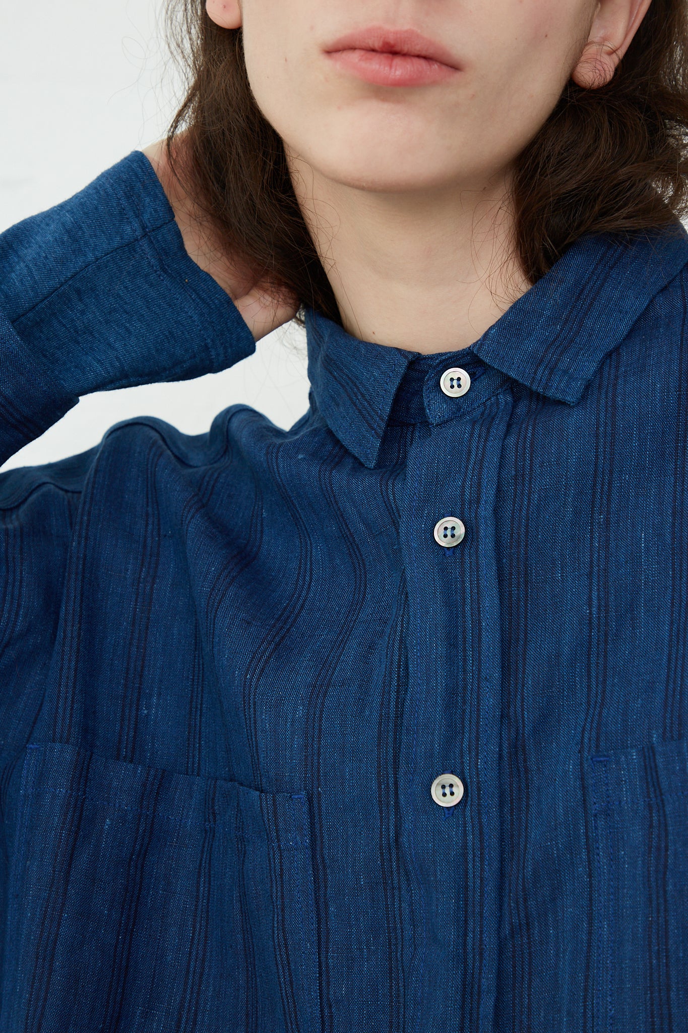 A woman wearing an Ichi Antiquités relaxed-fit Indigo Stripes woven linen shirt.