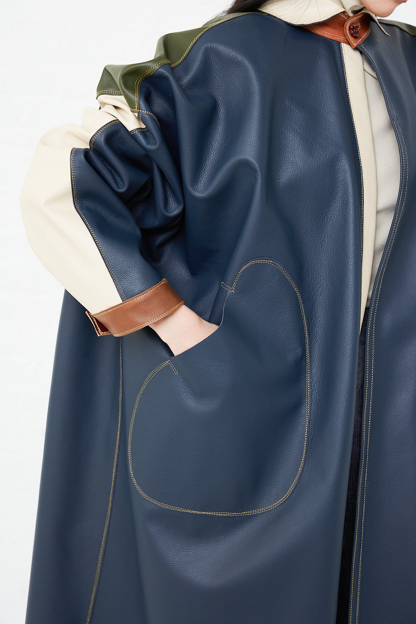 A woman wearing a Thank You Have A Good Day Leather Oversized Shirt Jacket in Color Block Blue with pockets and a button closure.