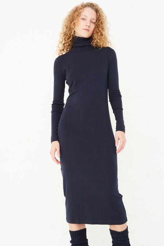 The model is wearing a slim fit Turtleneck Dress in Ink by Misha & Puff.
