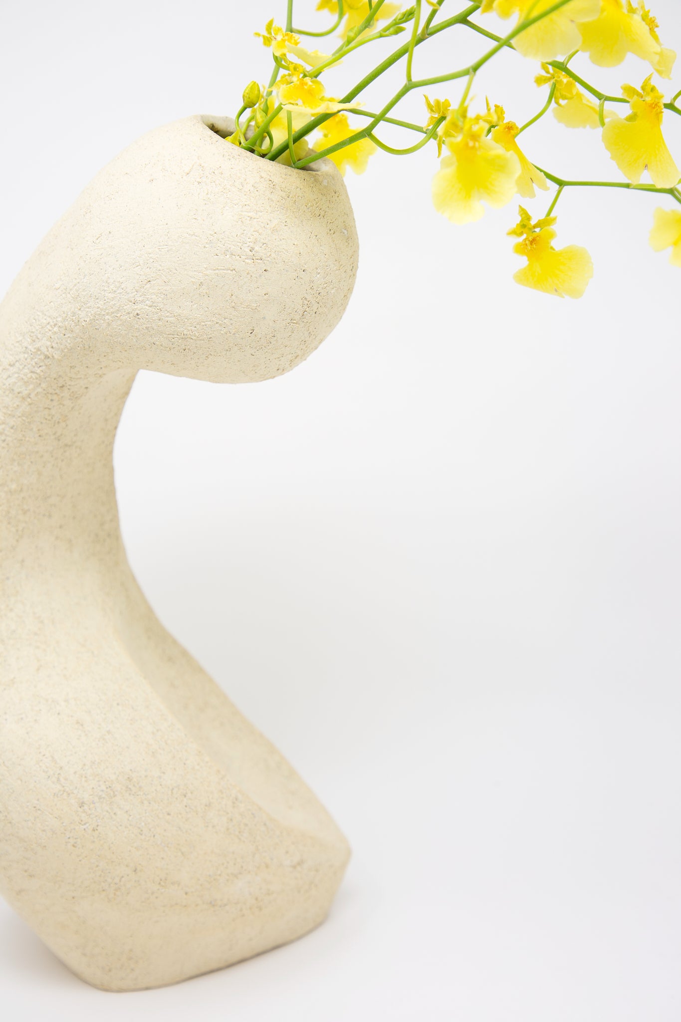 A Lost Quarry Large Hand Built Vessel No. 000711 Bud Vase with textured white sculpture clay, showcasing beautiful floral arrangements of yellow flowers.