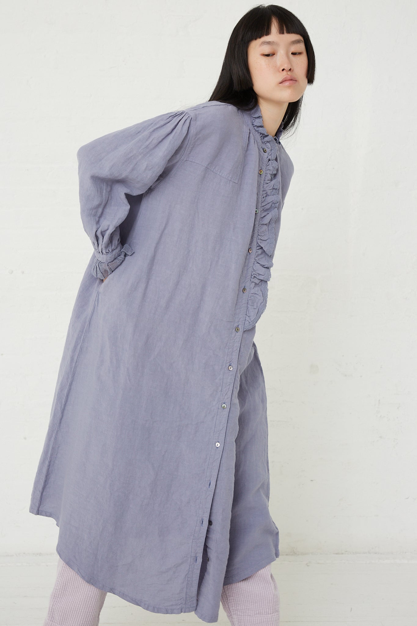 The model is wearing a nest Robe Linen Cotton Lace Omi-Zarashi Dress in Lavender with ruffles.