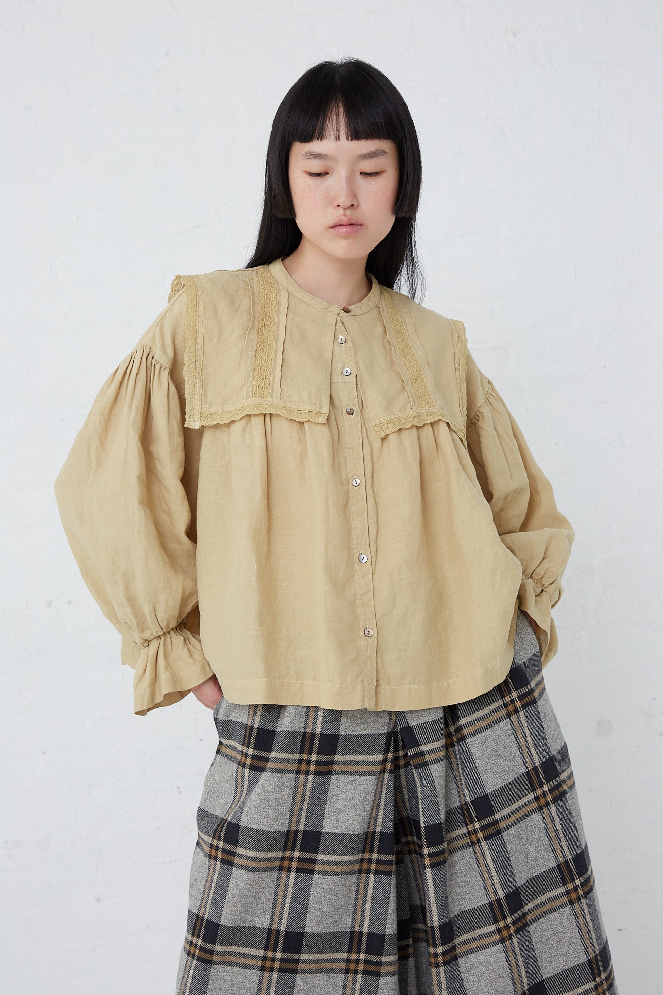 A woman wearing a Natural Dyed Linen Lace Blouse in Yellow by nest Robe.