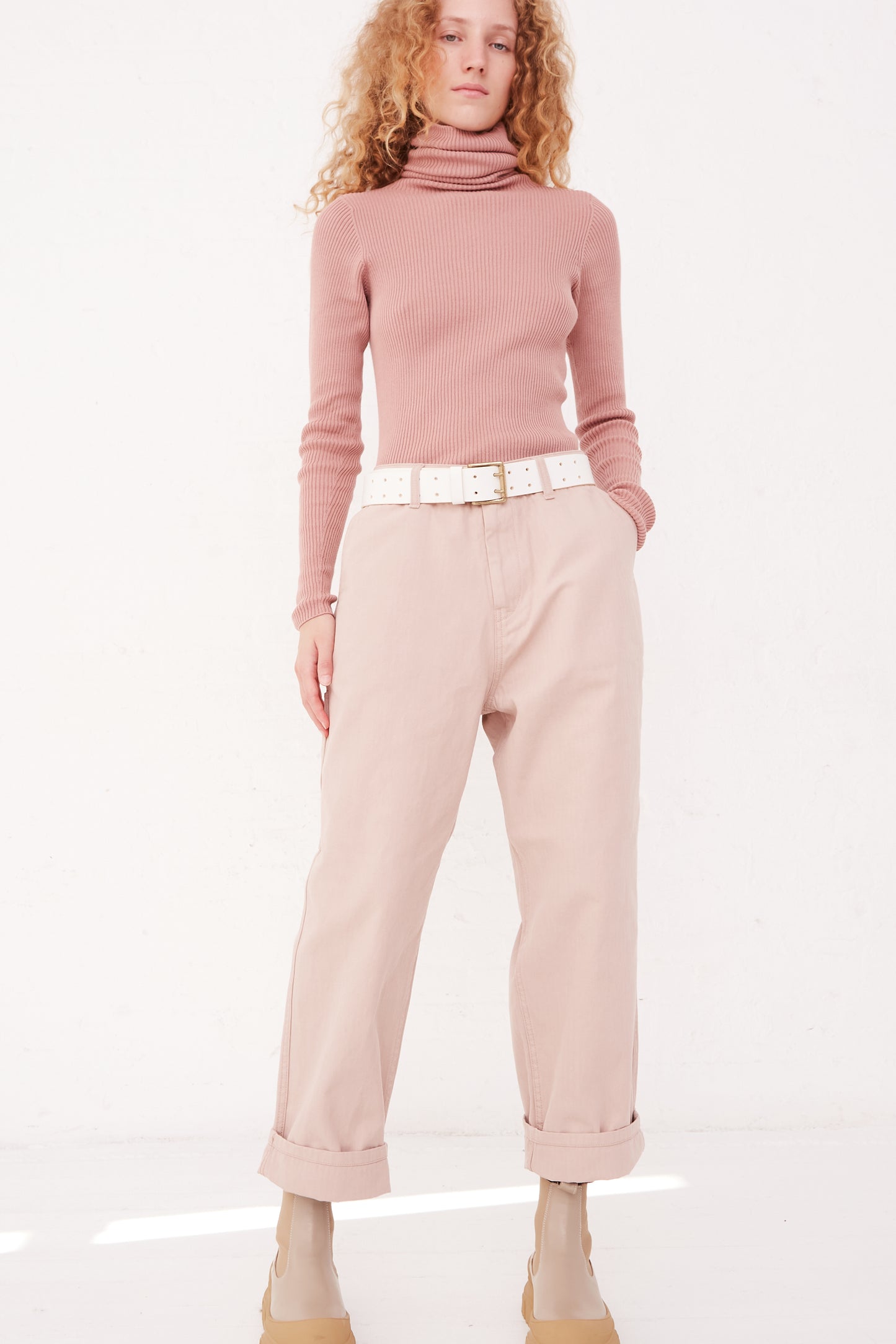 The model is wearing a relaxed fit, wide leg Herringbone Pants in Pink and Ichi Antiquités turtle neck sweater.