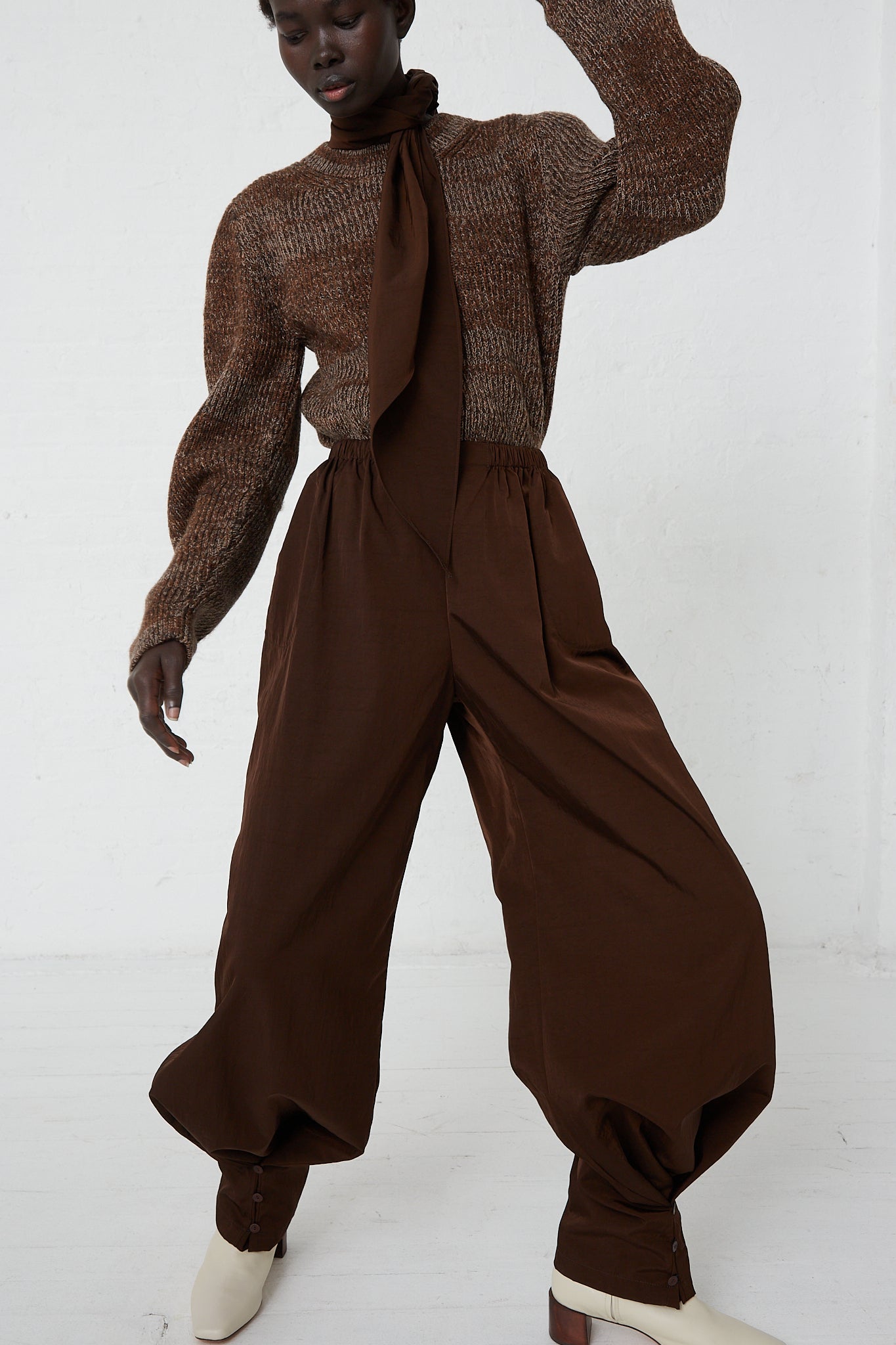 A woman wearing Large Drawstring Trousers in Choco by Veronique Leroy made of virgin wool and a sweater.