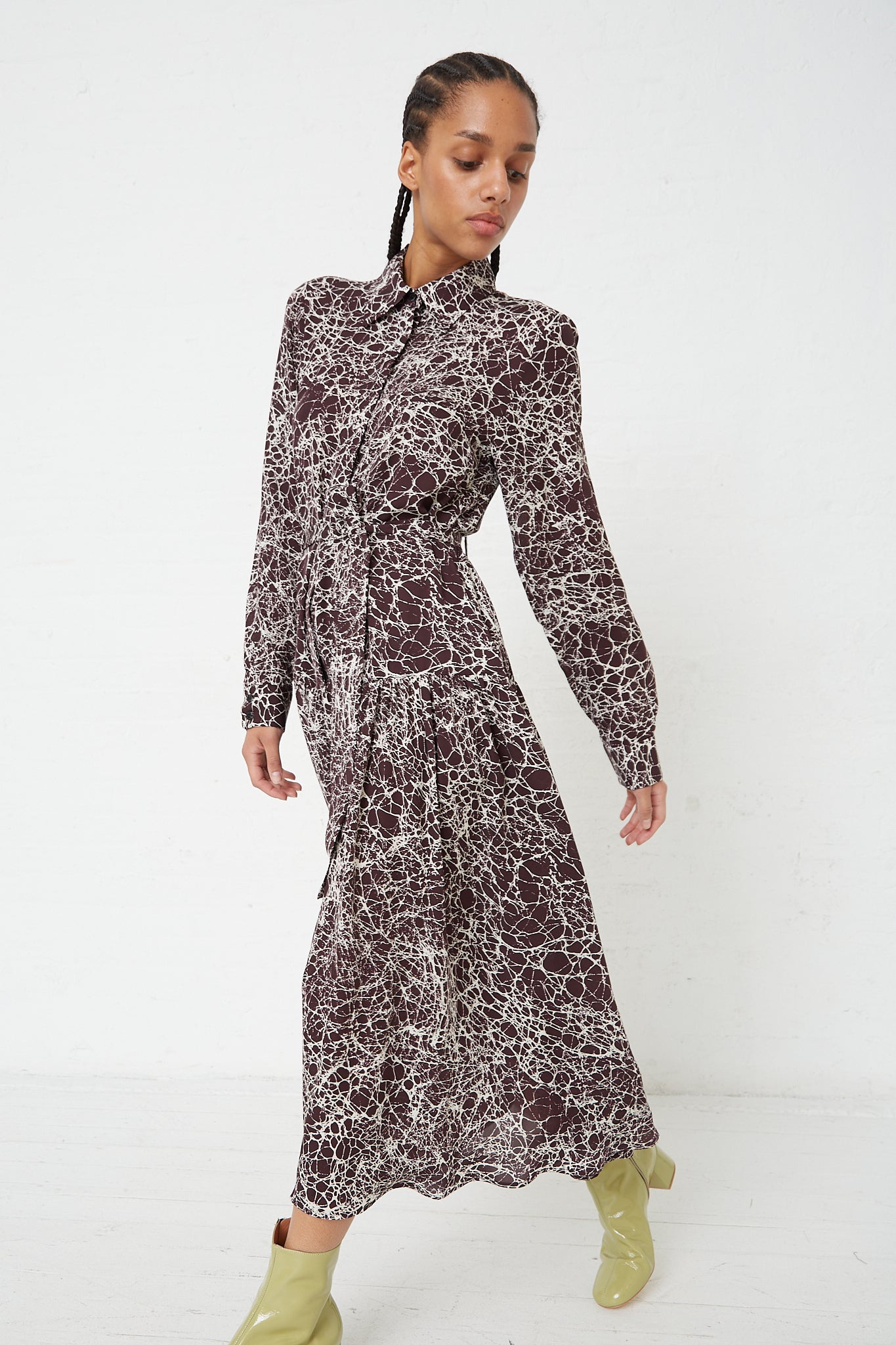 The model is wearing a long-sleeved Silk Marbled Georgette Jana Dress in Brown by Rachel Comey.