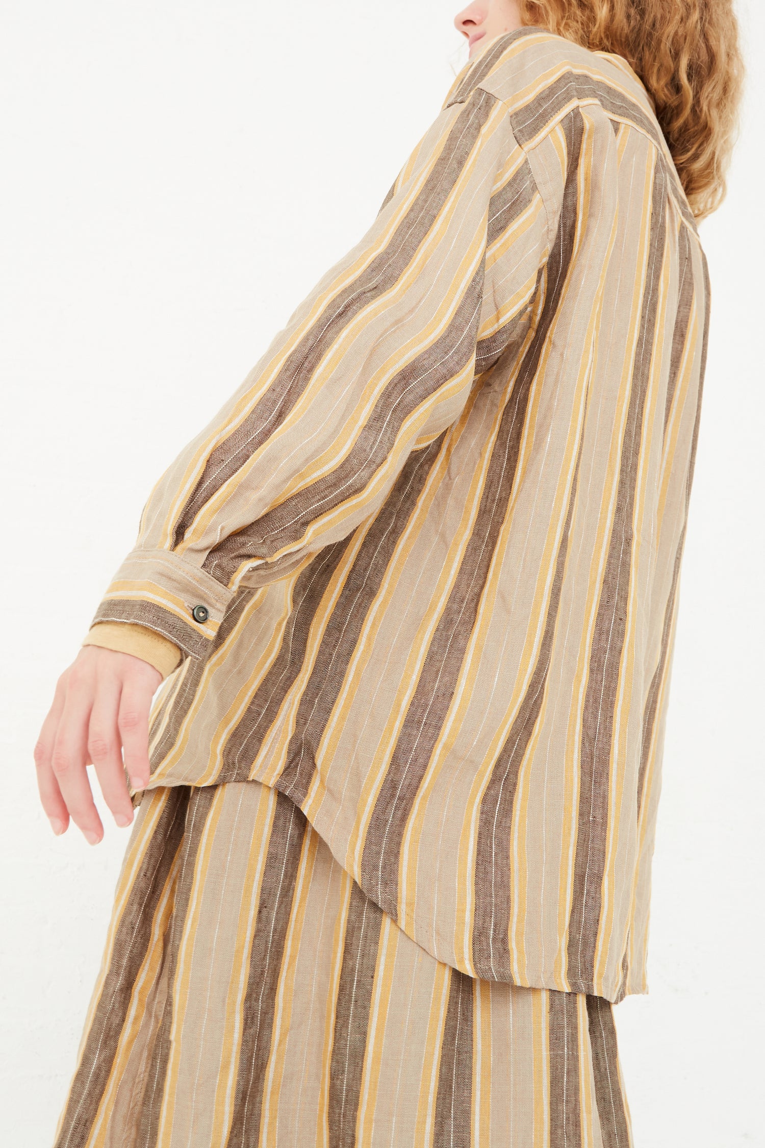 The back of a model wearing an Ichi Antiquités Linen Stripe Shirt in Mustard and skirt in a relaxed fit.