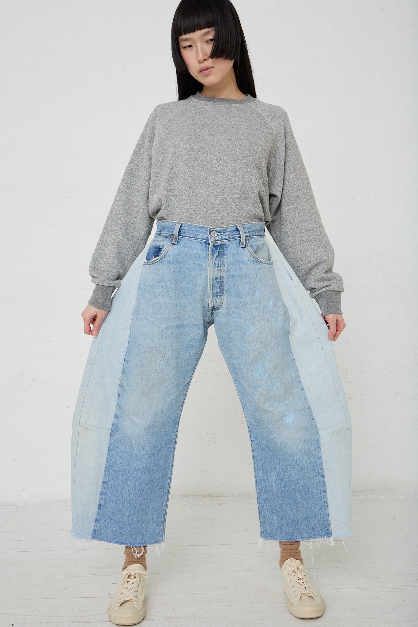 A woman wearing a B Sides Lasso Jean in Vintage Indigo denim jeans and a sweater.