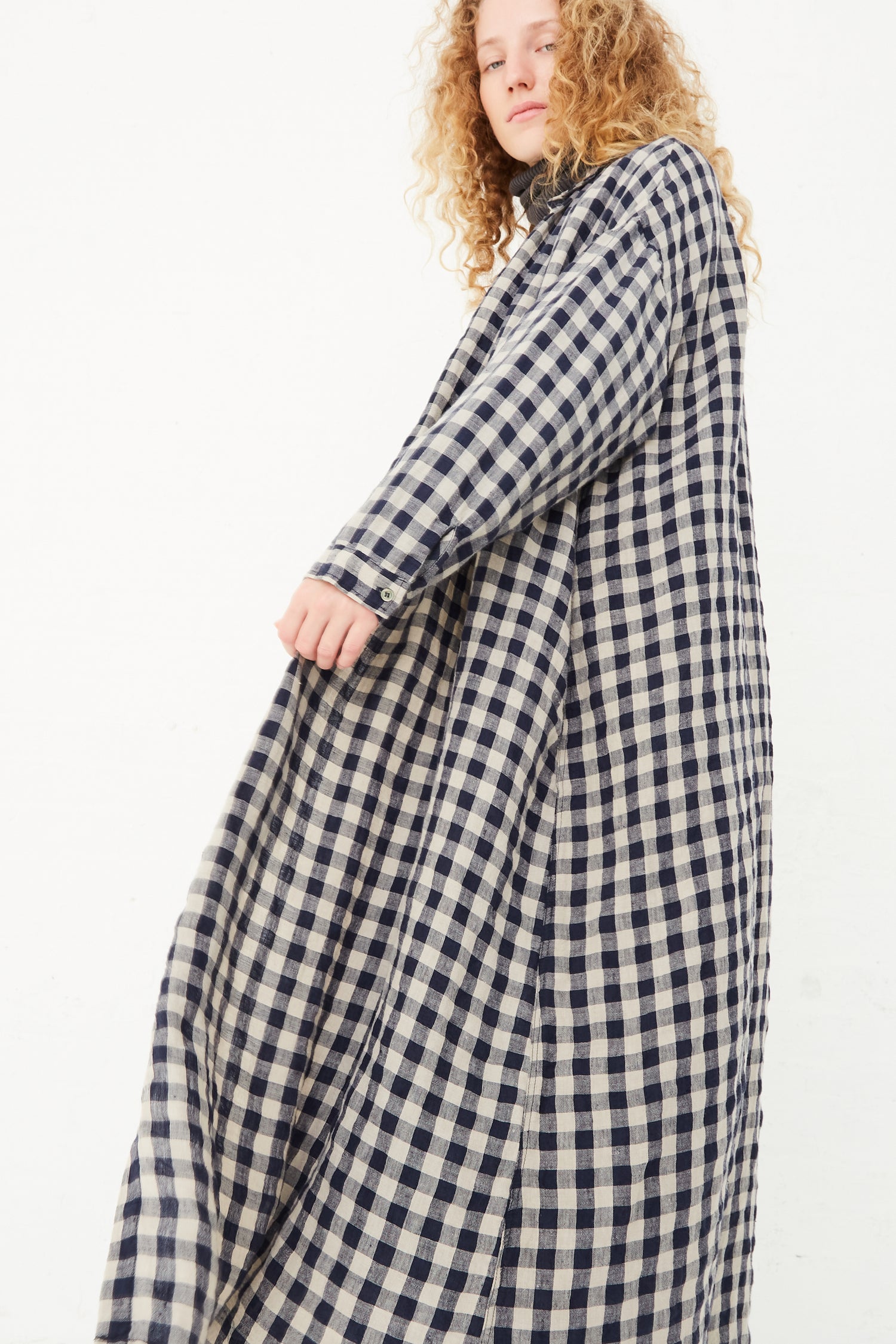 A woman wearing an Ichi Antiquités Azumadaki Linen Gingham Dress in Beige coat.