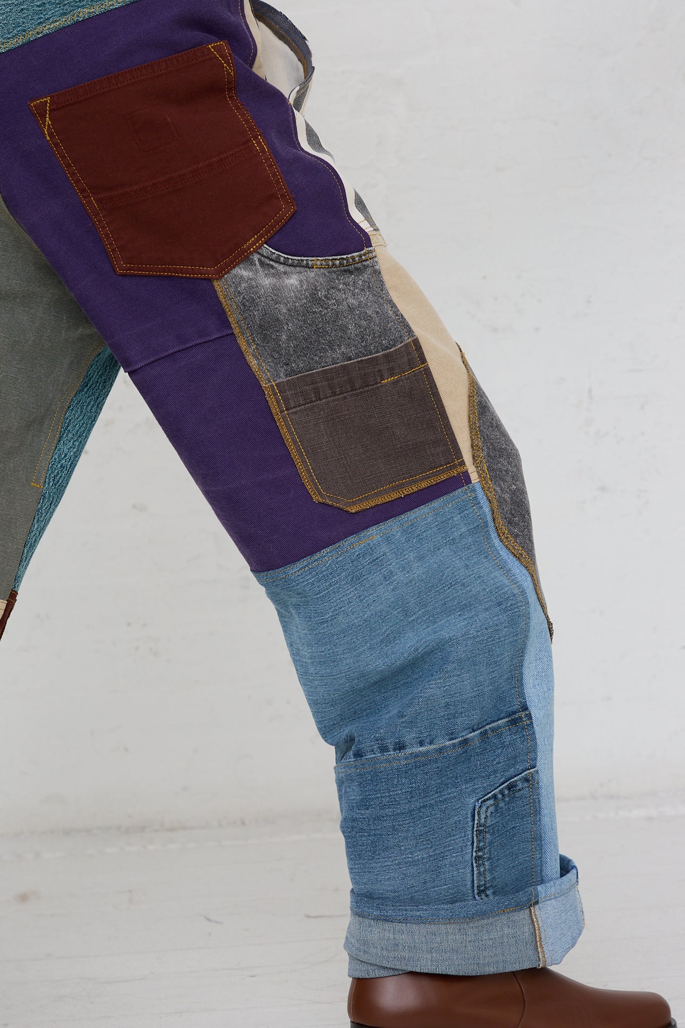 A person wearing a colorful pair of WildRootz Reworked Jeans in Multicolor II.