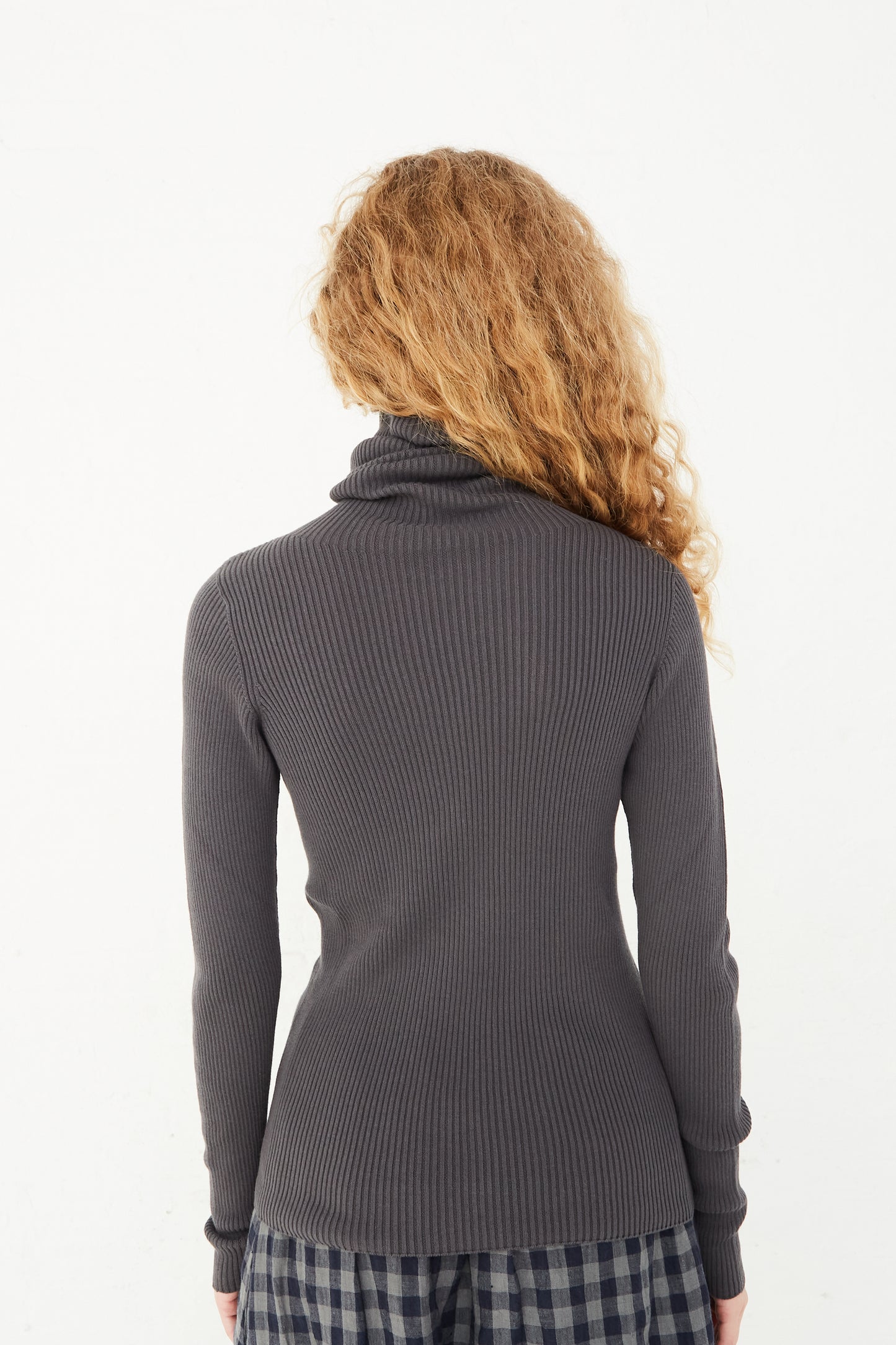 The back view of a model wearing a Ichi Antiquités Rib Turtleneck in Charcoal.