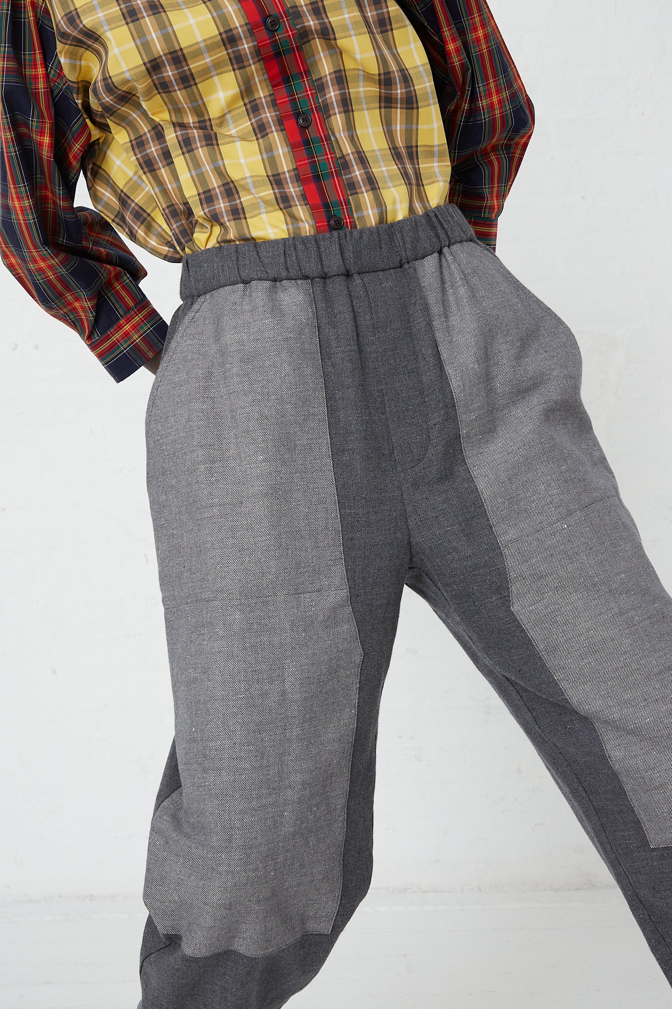 A woman wearing a KasMaria Cotton Linen Flannel Front Patch Pant in Gray with an elasticated waist and a plaid shirt.