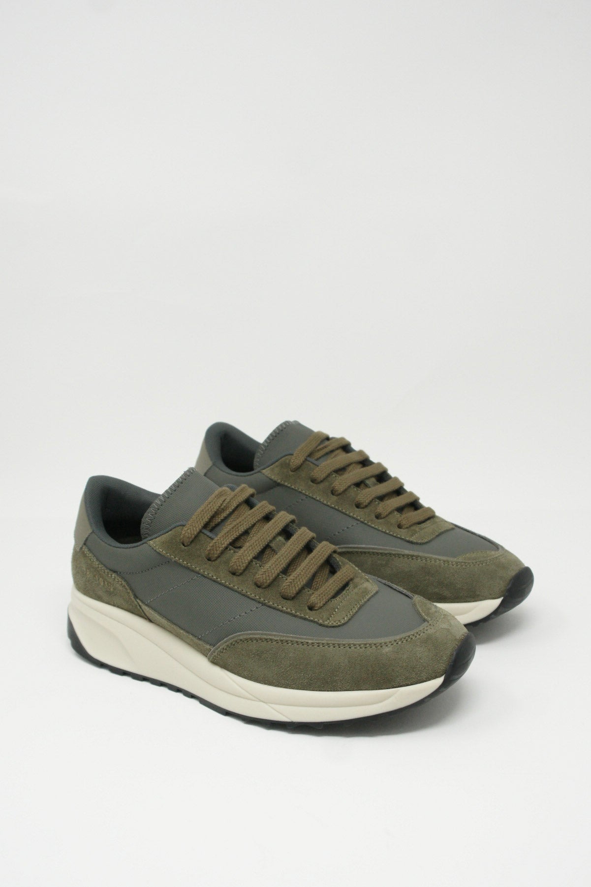 A pair of olive Common Projects Track Technical Article Sneaker 6140 with suede overlays on a white background.