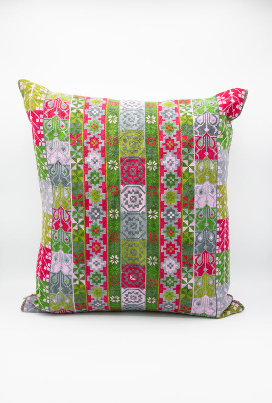 A Malak Hand Embroidered Pillow in Emerald and Crimson by Kissweh with a geometric pattern in green and pink.