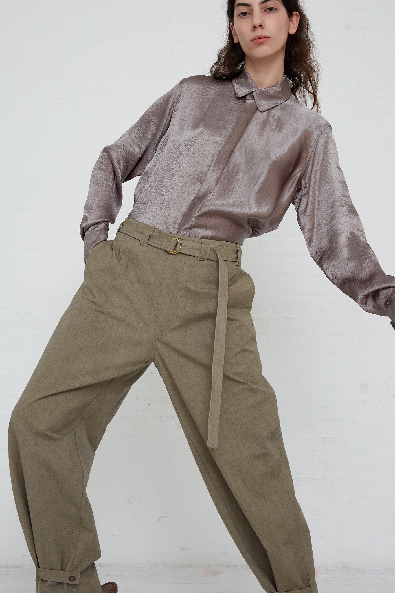 A woman in khaki Belted Trouser in Fatigue by Lauren Manoogian and a grey shirt with adjustable cuff.