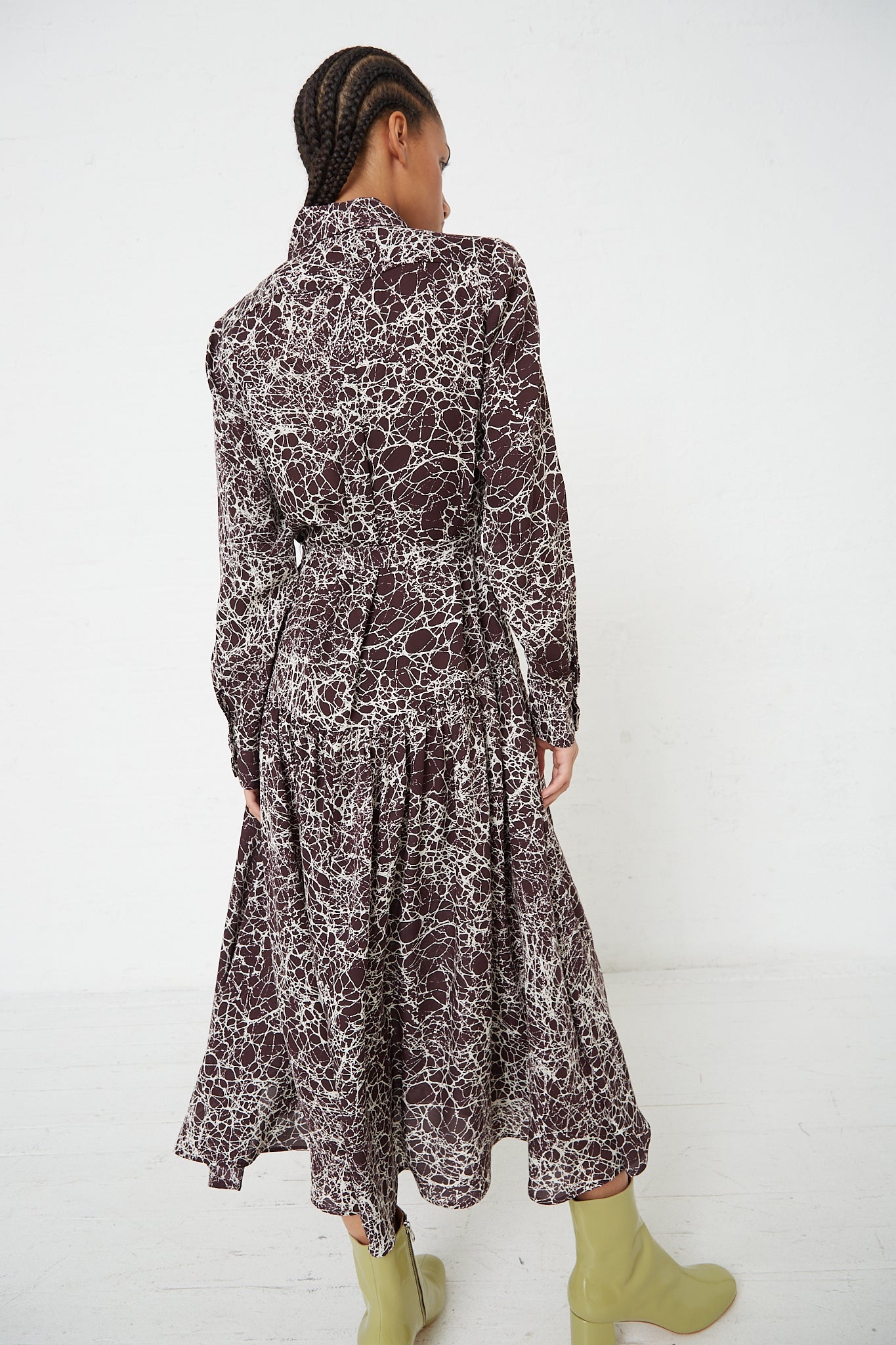 The back view of a woman wearing a Rachel Comey Silk Marbled Georgette Jana Dress in Brown.