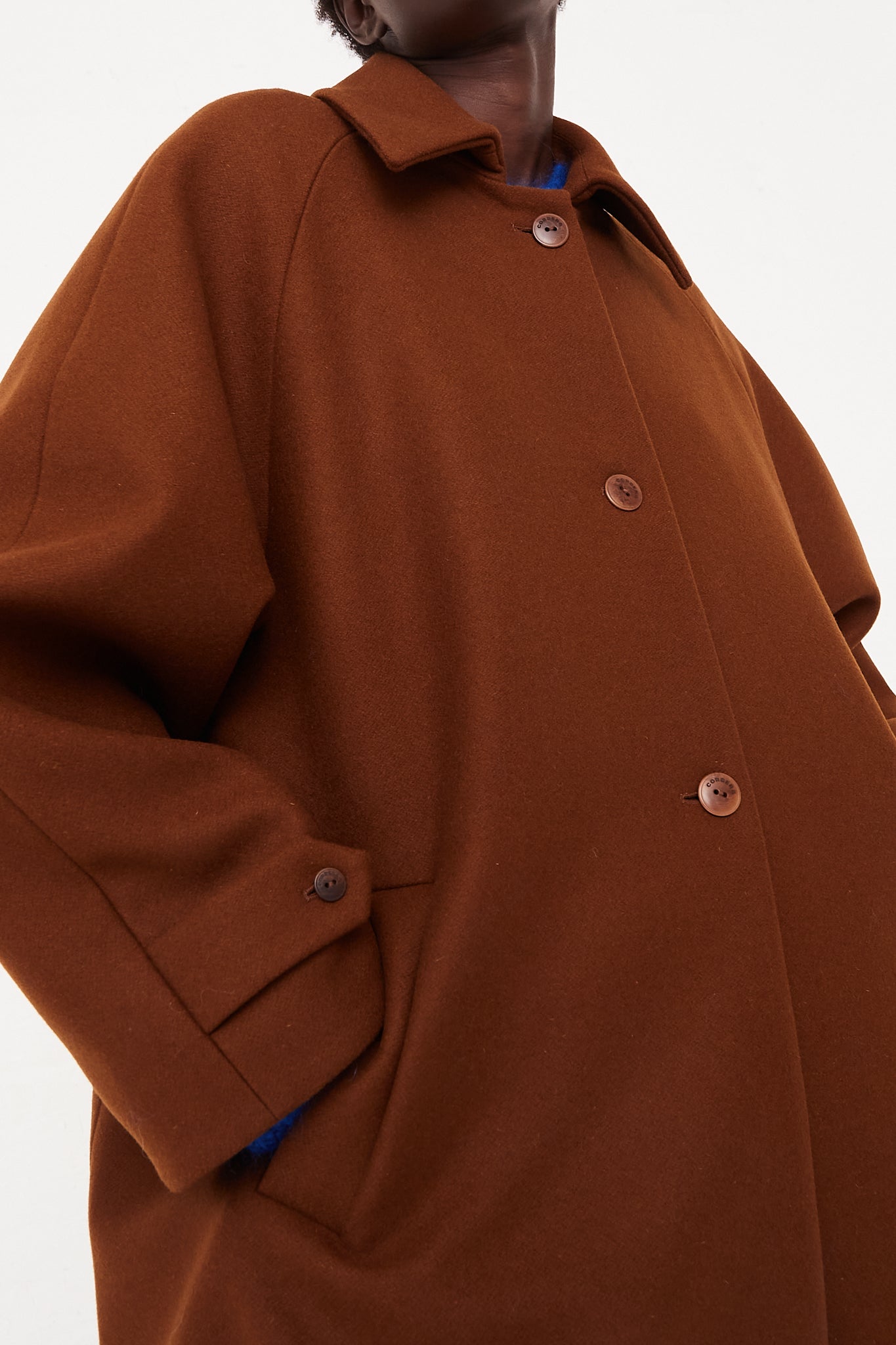 CORDERA Wool Coat Camel | Oroboro Store | Front image of coat uploclose buttoned up on model hand in pocket