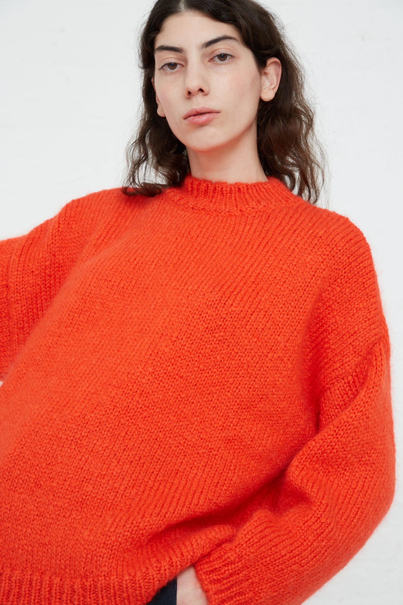 A model wearing an oversized Cordera Mohair Sweater in Tangerine.