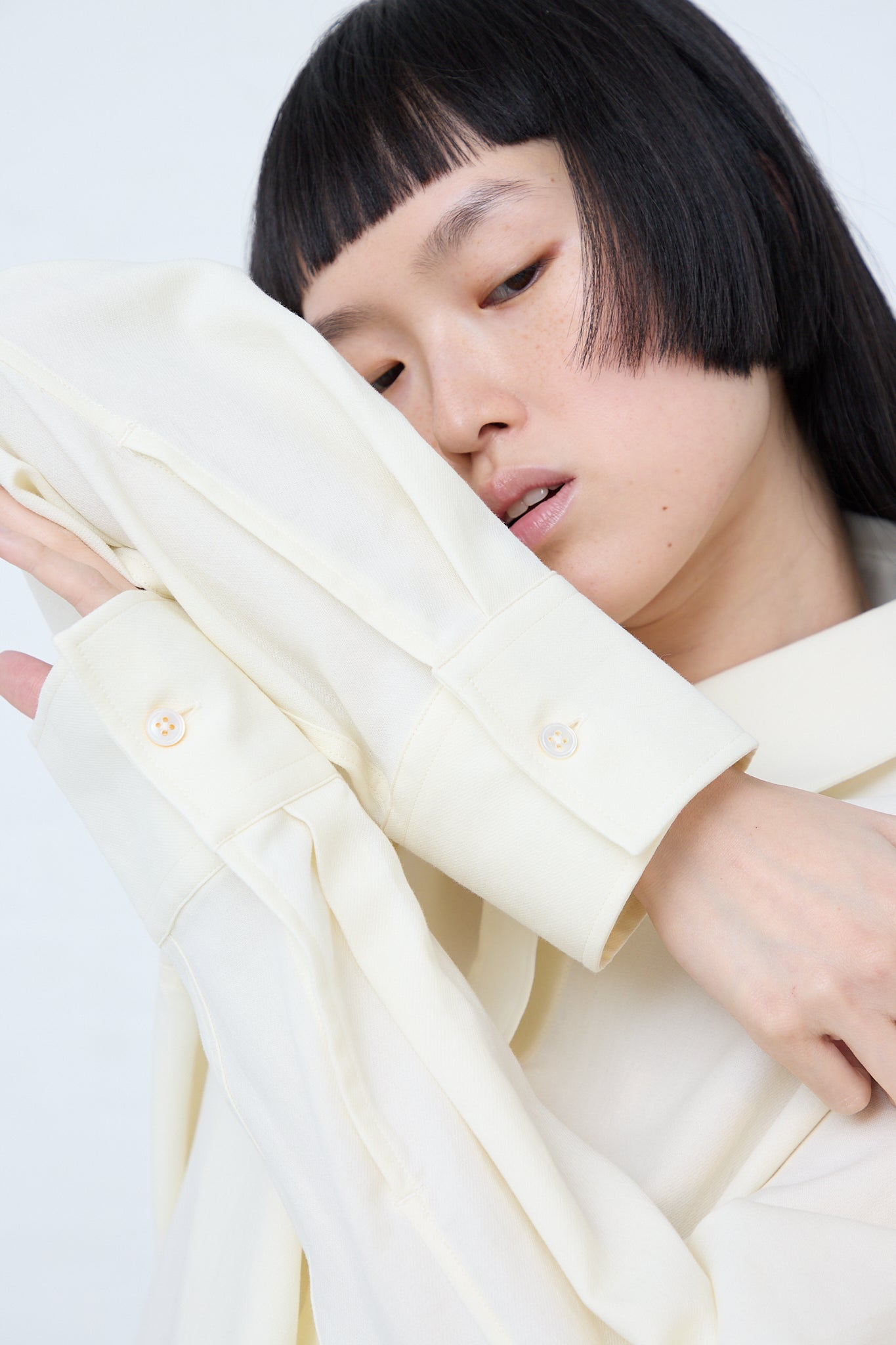 A woman wearing a Santos Overshirt in Parchment by Studio Nicholson. Up close view.