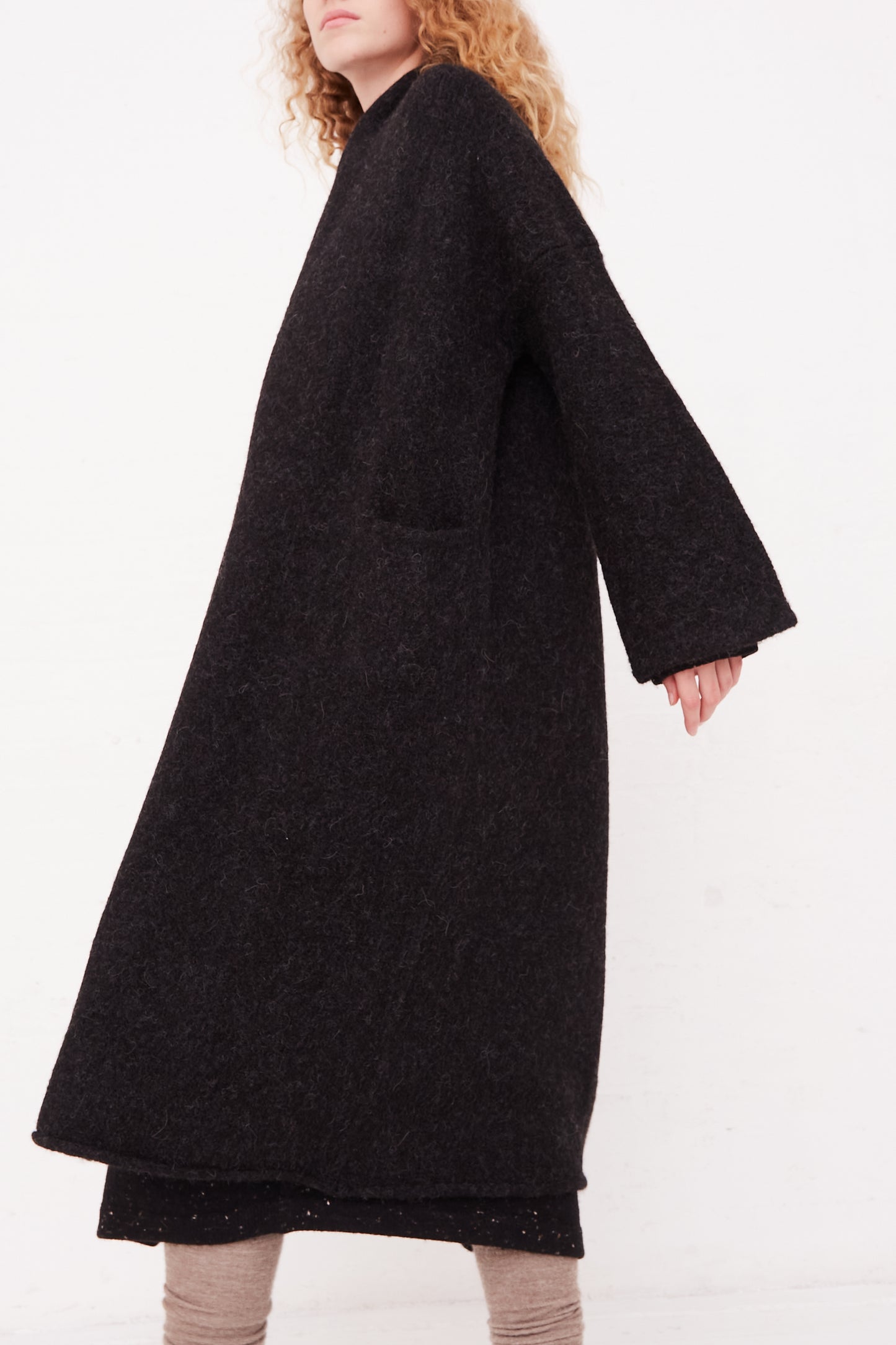 A woman wearing a Lauren Manoogian Long Shawl Cardigan in Black coat.