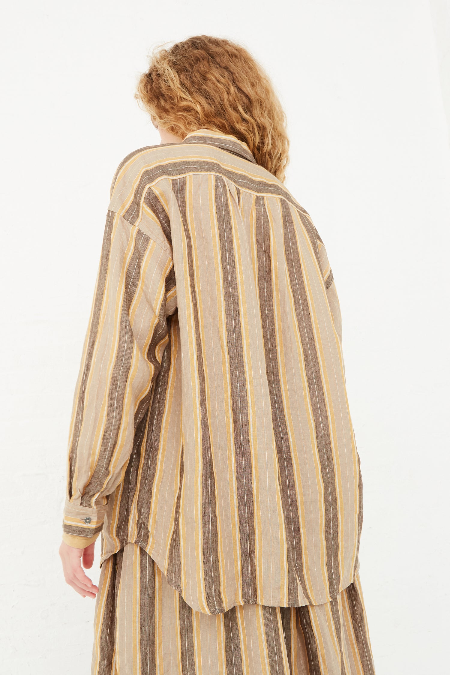 The back view of a woman wearing an Ichi Antiquités Linen Stripe Shirt in Mustard.