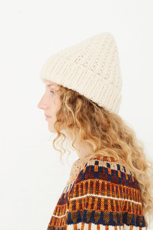 A woman wearing a Misha & Puff Puffy Ros Hat in String, available at Oroboro store.