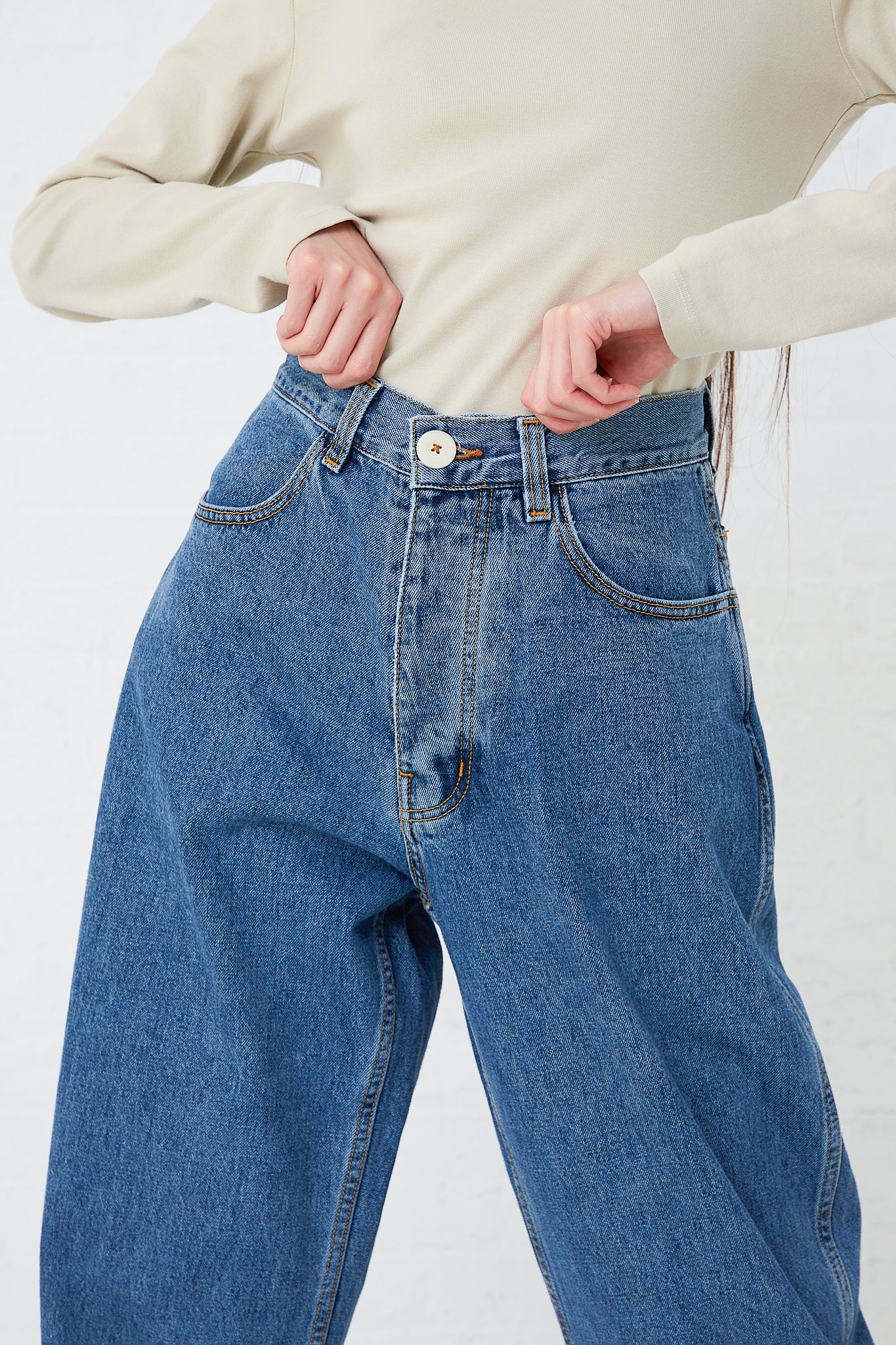 A woman is posing in a pair of Jesse Kamm's Japanese Denim California Wide jeans in Cowboy Blue.