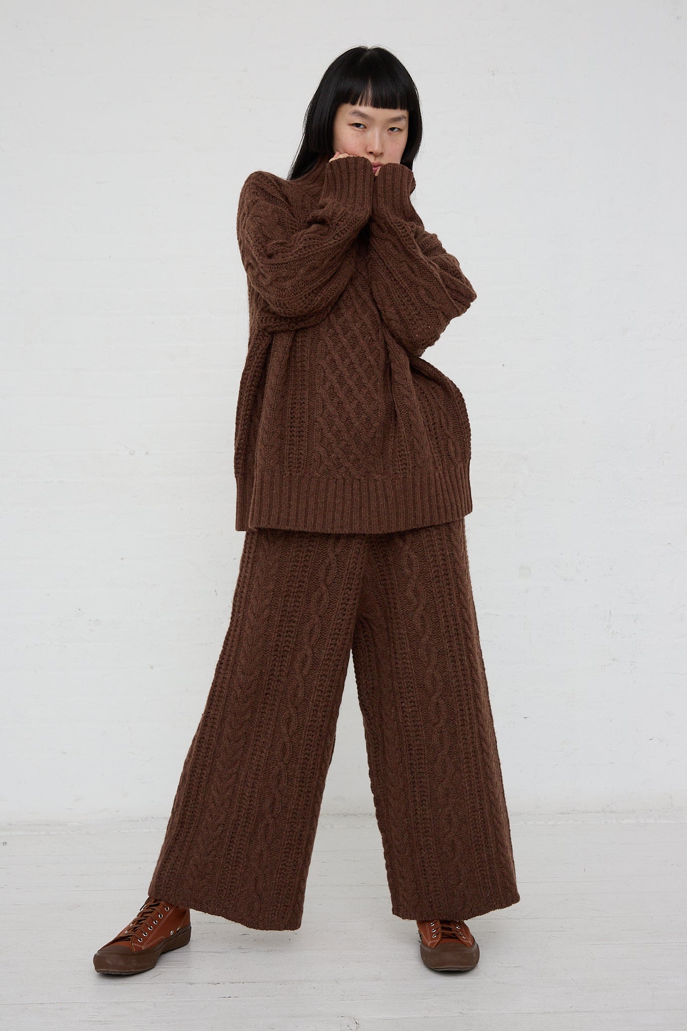 A woman wearing an Ichi Knit Turtleneck Pullover in Brown, a relaxed fit. Full length view.