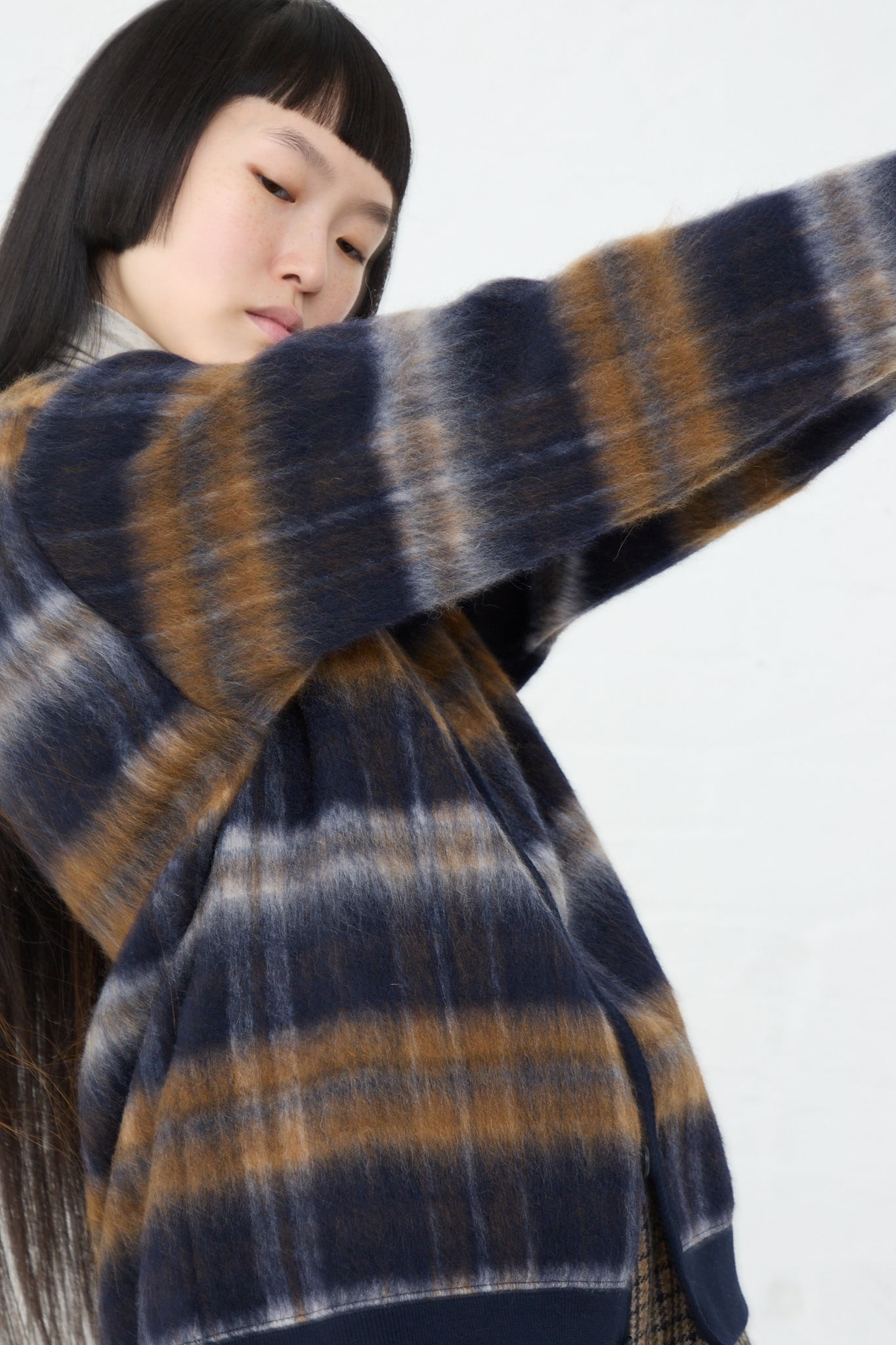 A woman wearing an Ichi Knit Cardigan in Navy, featuring a trendy patterned wool blend fabric. Side view.