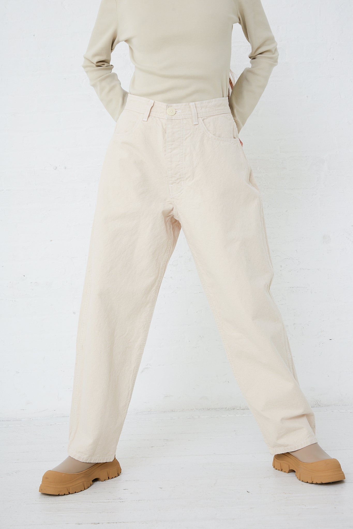 A woman wearing beige Jesse Kamm relaxed-fit pants and an organic cotton tee shirt.