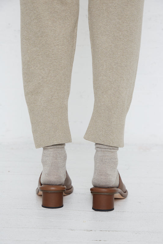 The back of a person wearing Lauren Manoogian's Base Pant in Stone Melange and tan shoes and socks in a relaxed fit pant.